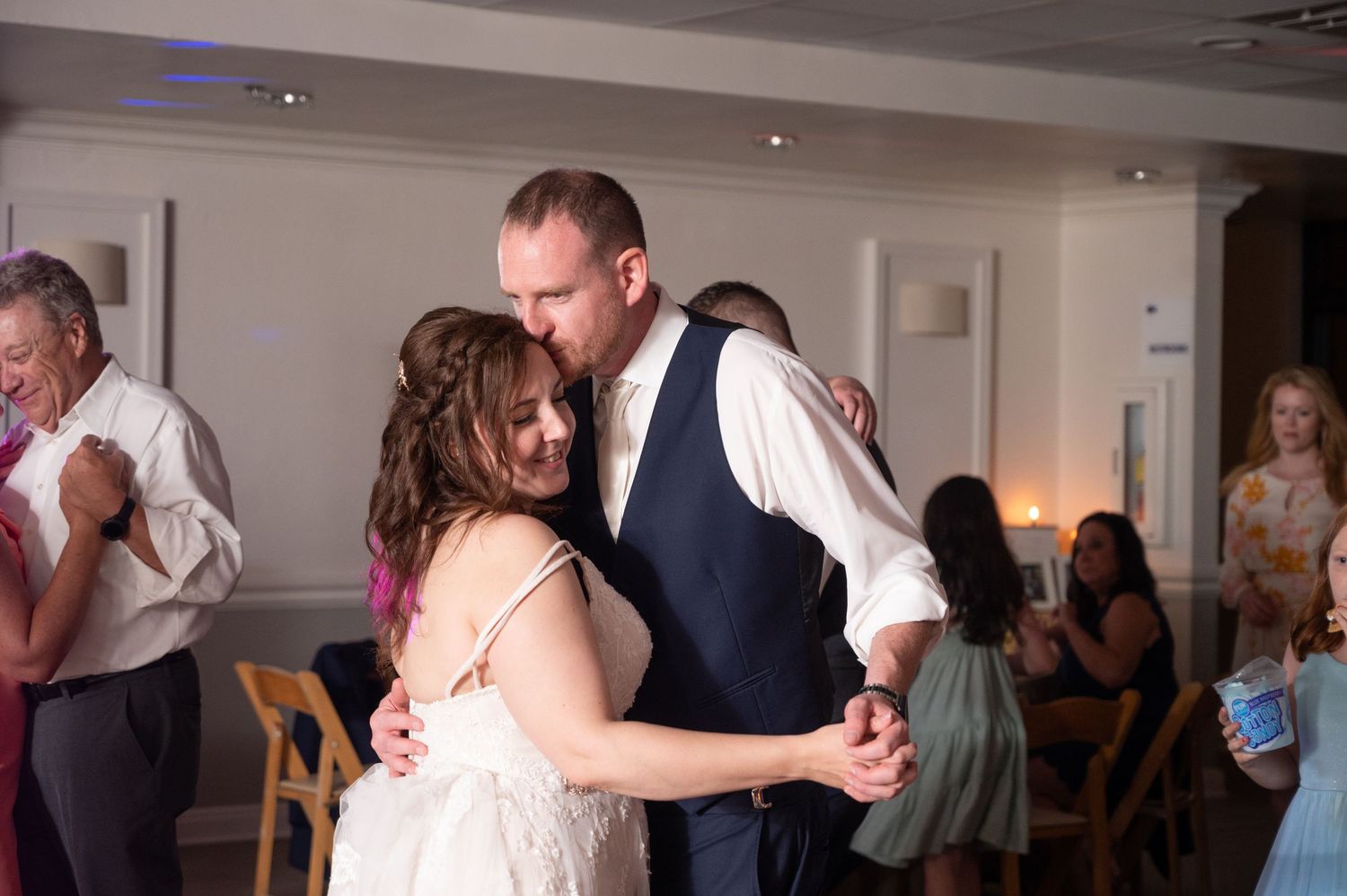 Wedding reception dance floor filled with guests enjoying celebration indoors.