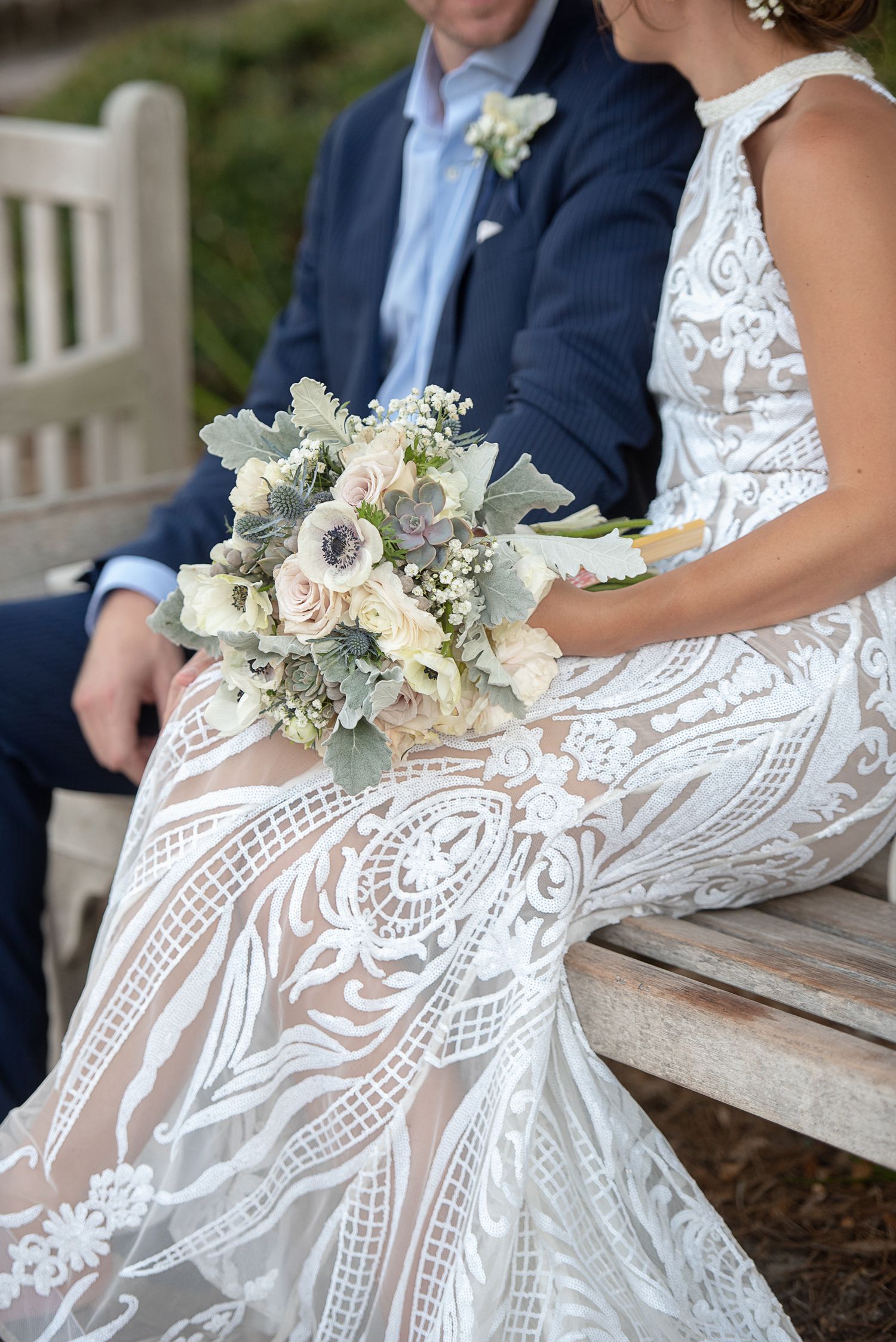 Elegant lace wedding dress detail with delicate floral bouquet. St. Augustine Beach Wedding.