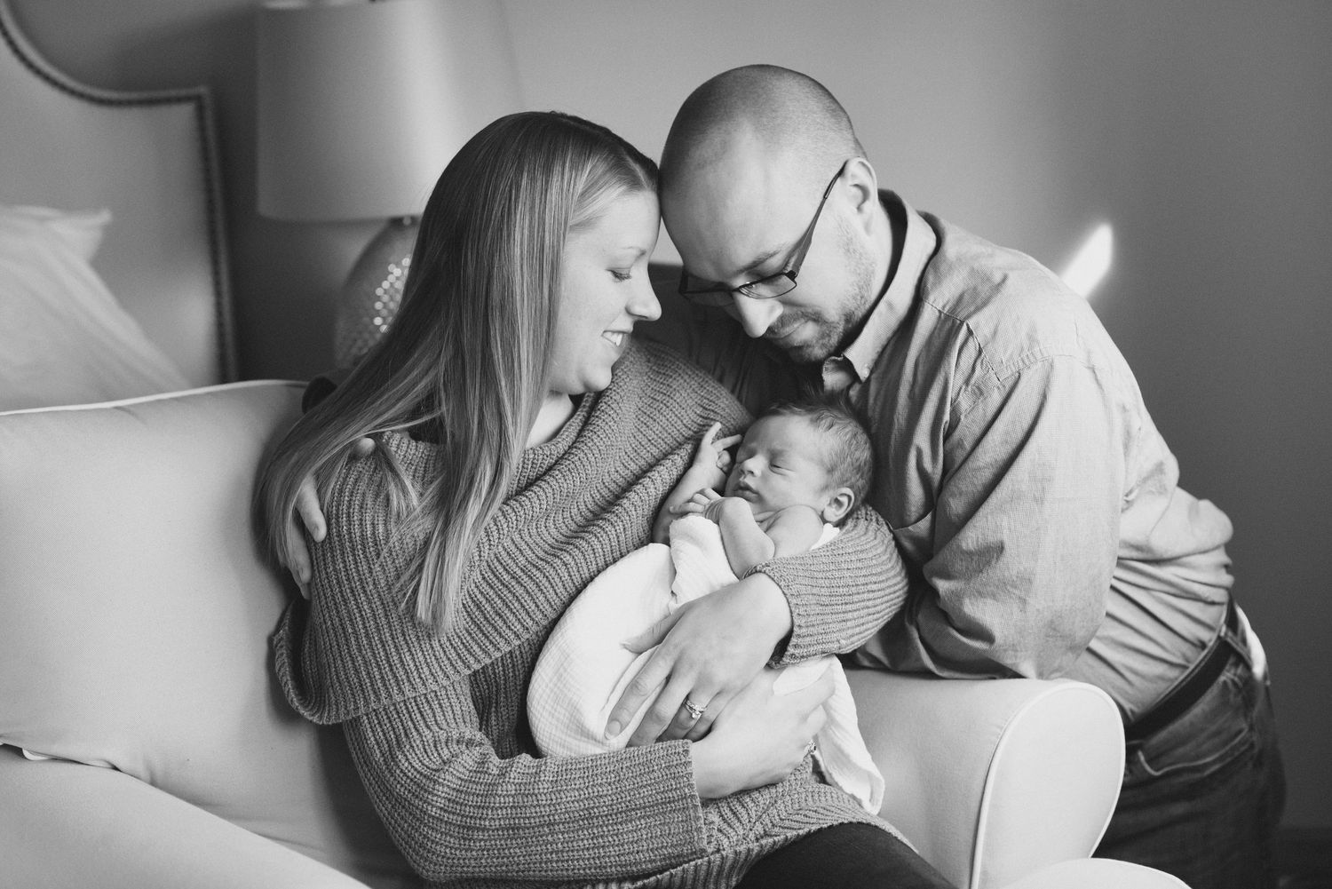Black and white photo series showing intimate moments between a couple cuddling and embracing on a couch.