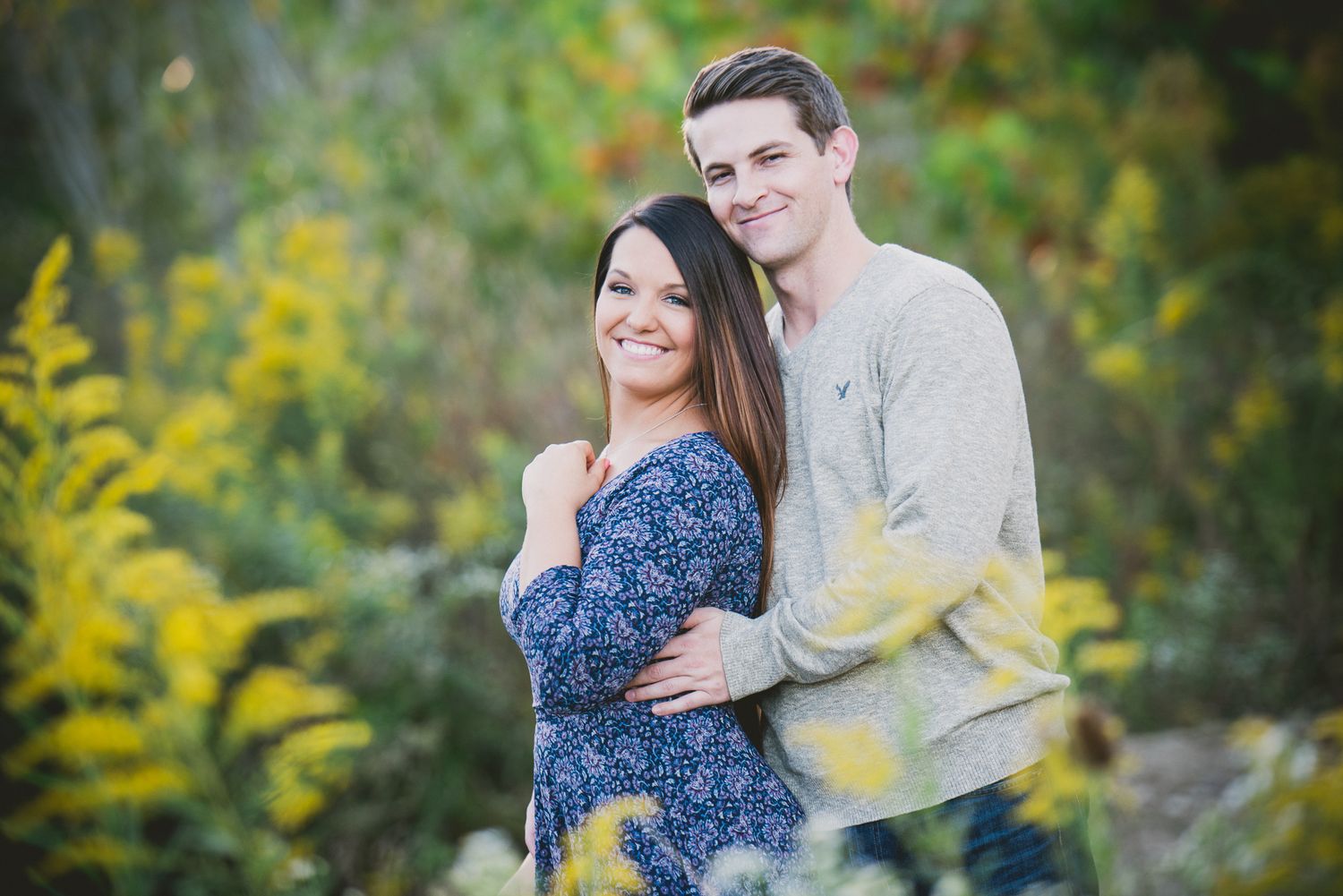 Couple sharing joyful moment in garden surrounded by autumn flowers.