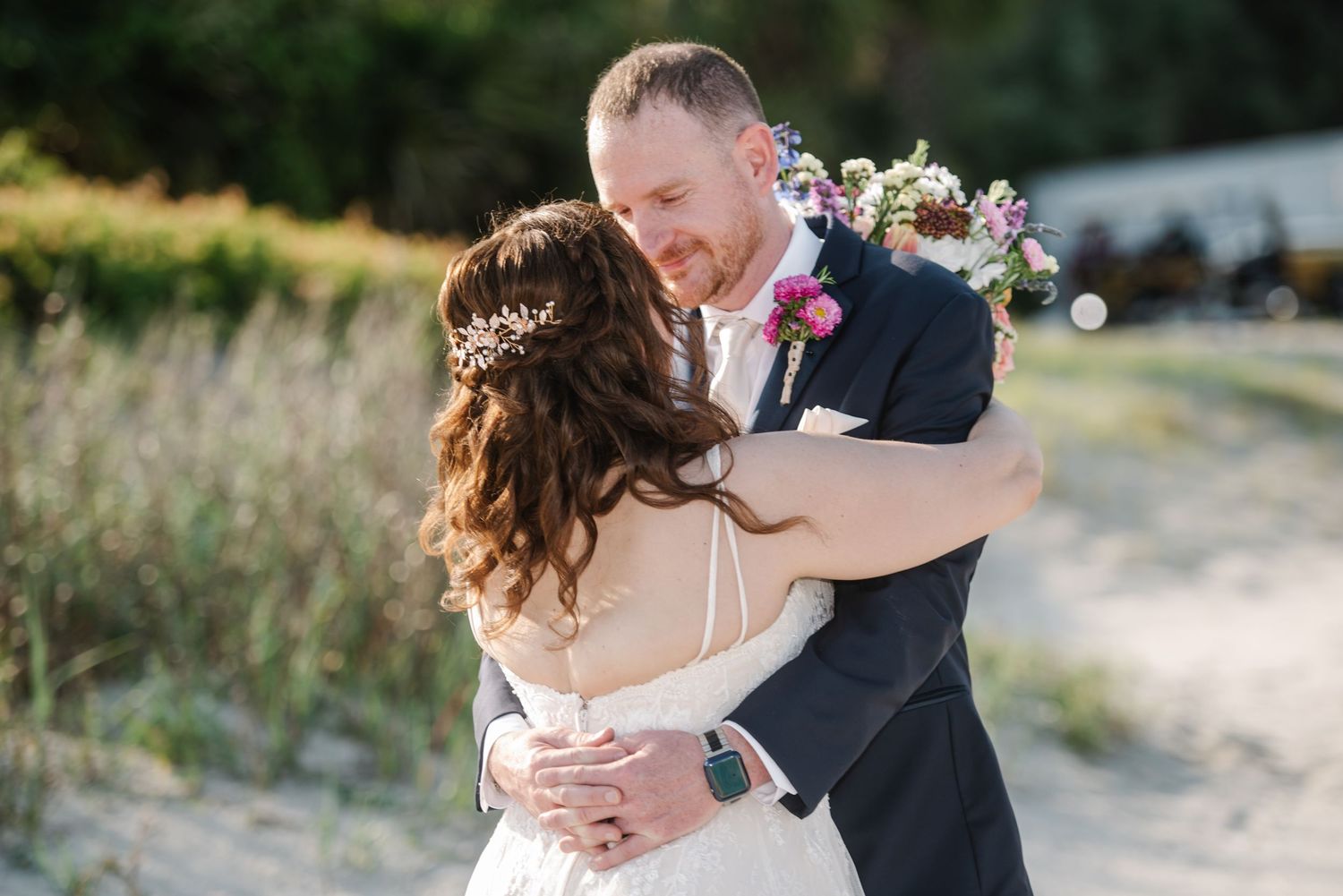 Candid wedding couple moments captured on a scenic beach with natural vegetation.