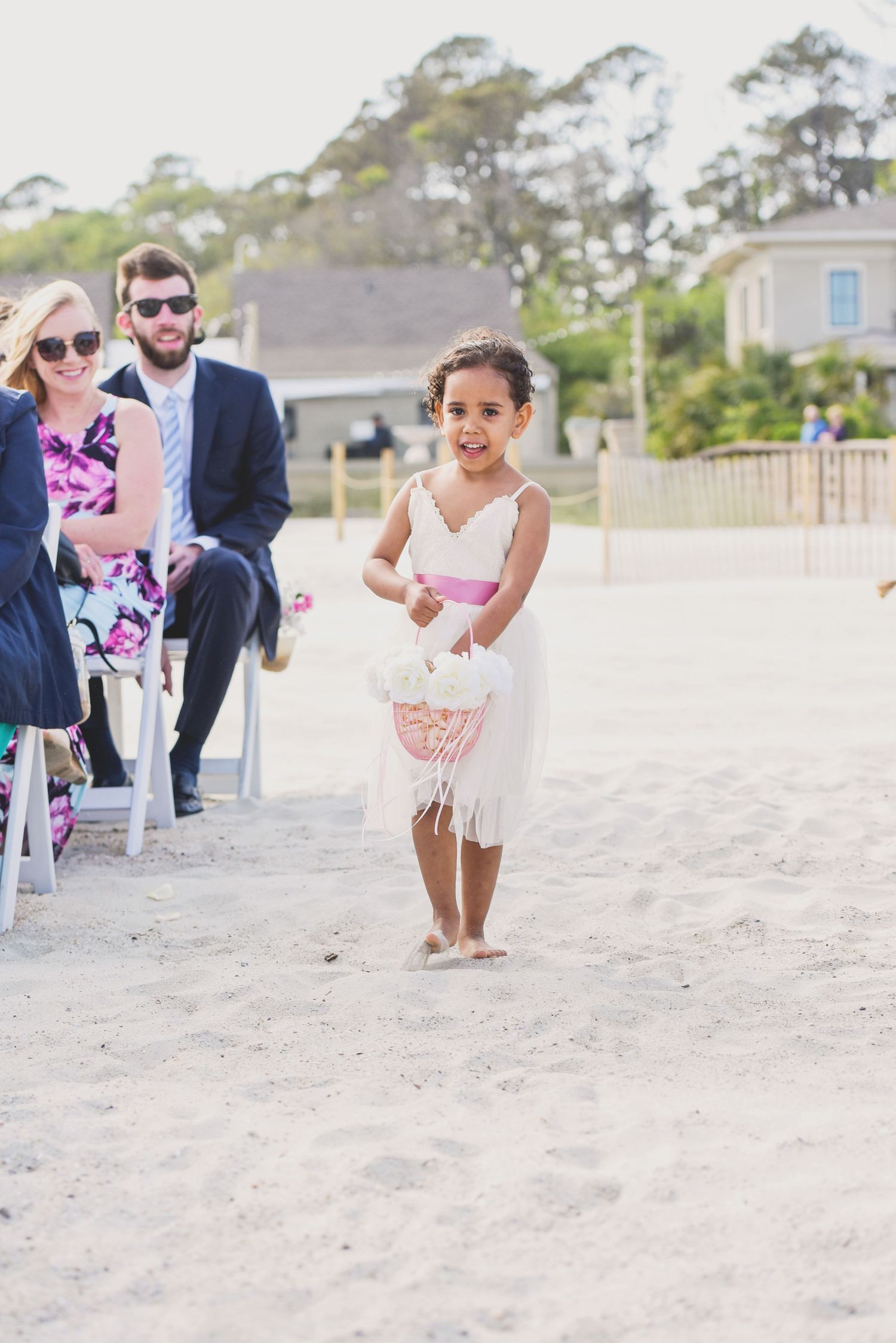 Wedding guests enjoy a casual moment on a sunny beach.