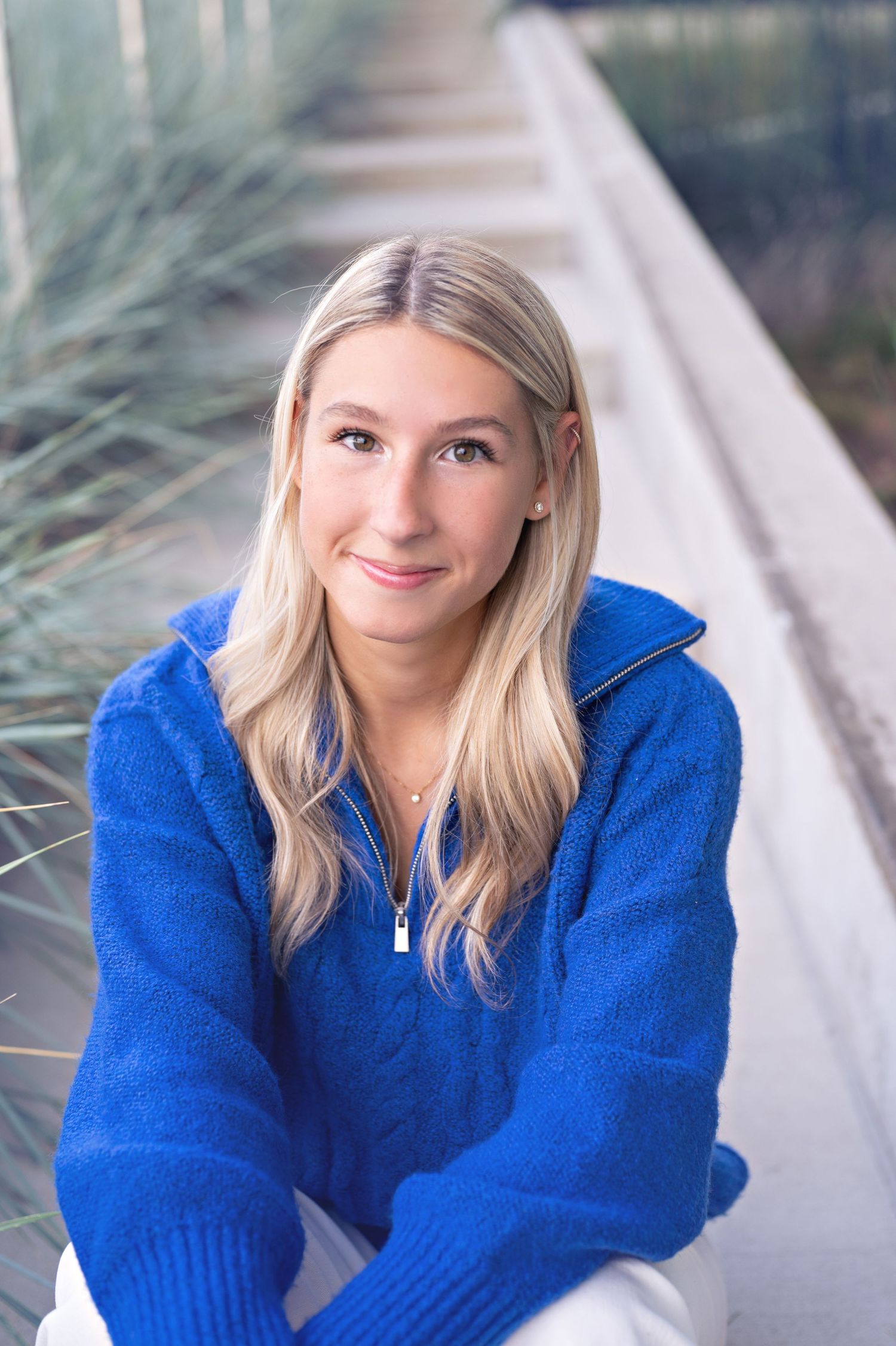 A cozy blue sweater outfit is styled for an outdoor winter photoshoot.