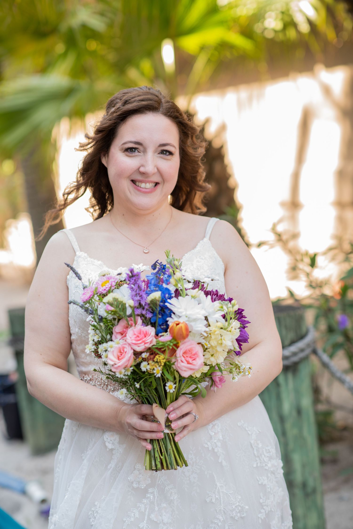 Bridal portraits in natural sunlight with vibrant wildflower bouquet.