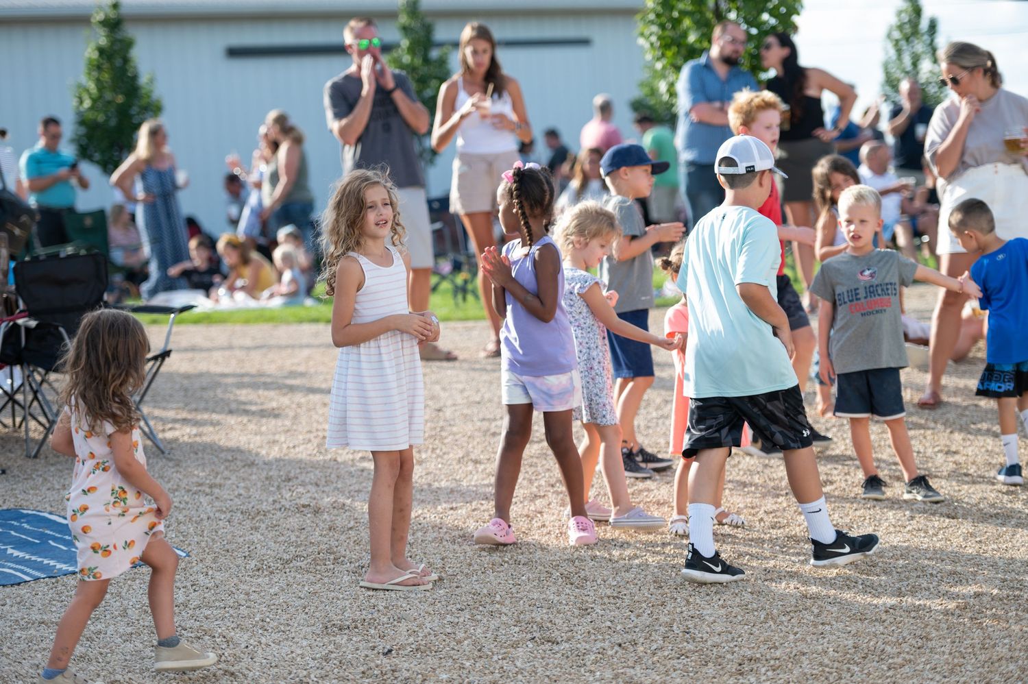 A group of children participate in an outdoor summer activity on a sunny day.
