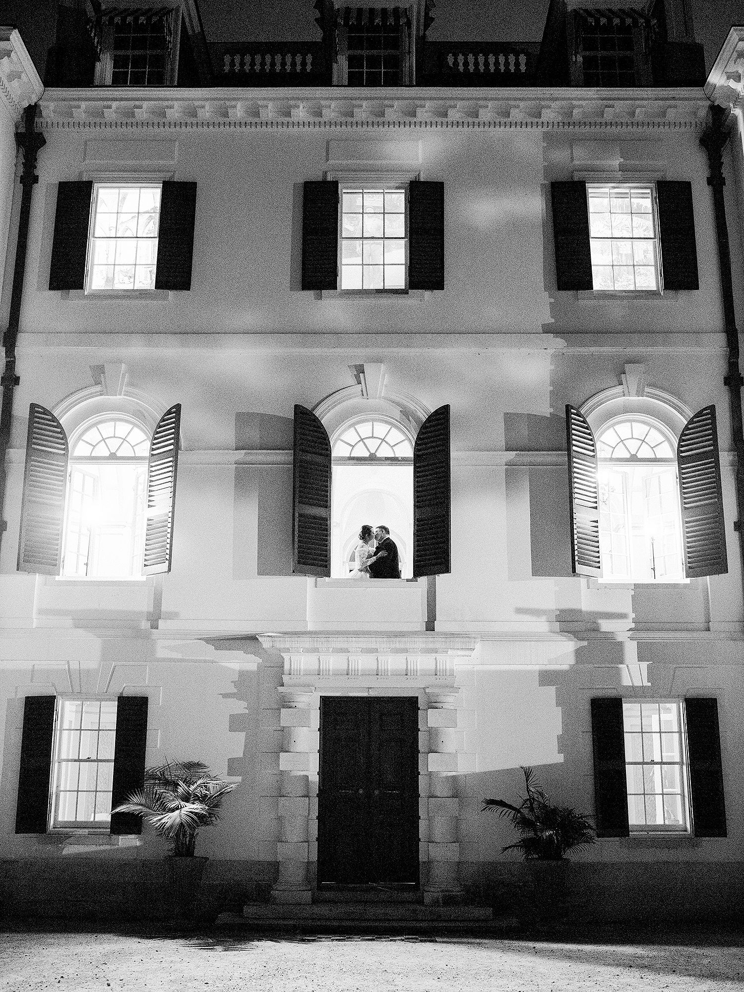 Interior of a historic white building with arched windows and classical architectural details. NYC wedding photographer.