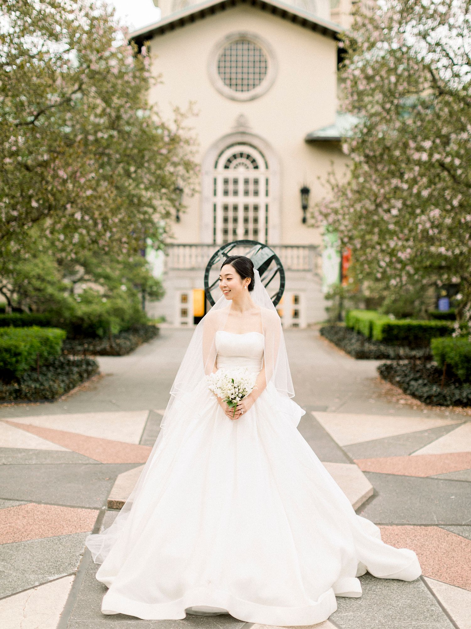 Wedding photography session in front of a classic church building with elegant bridal gown. NYC wedding photographer.