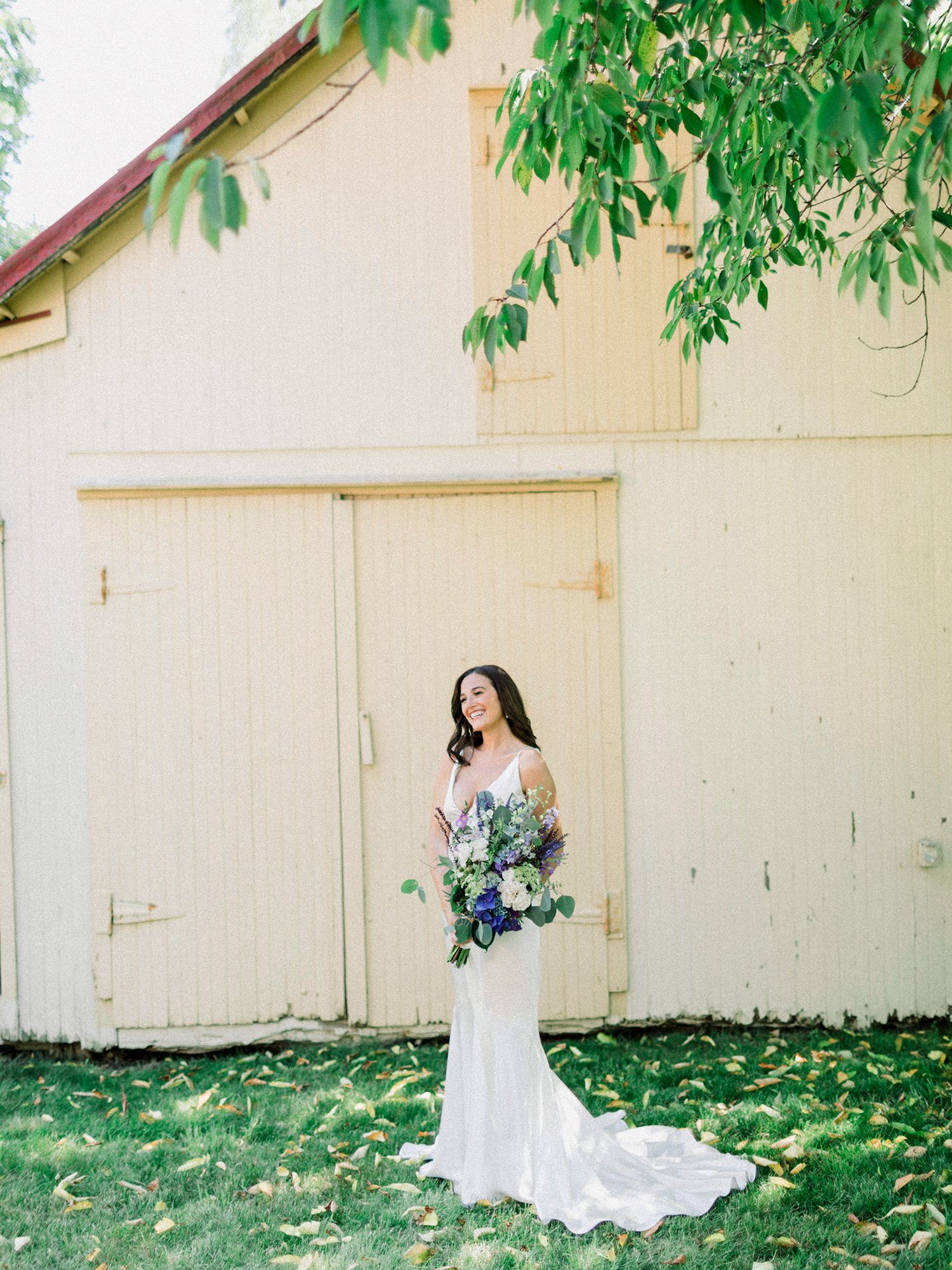 Classic bridal portraits against cream-colored building with trailing greenery overhead.