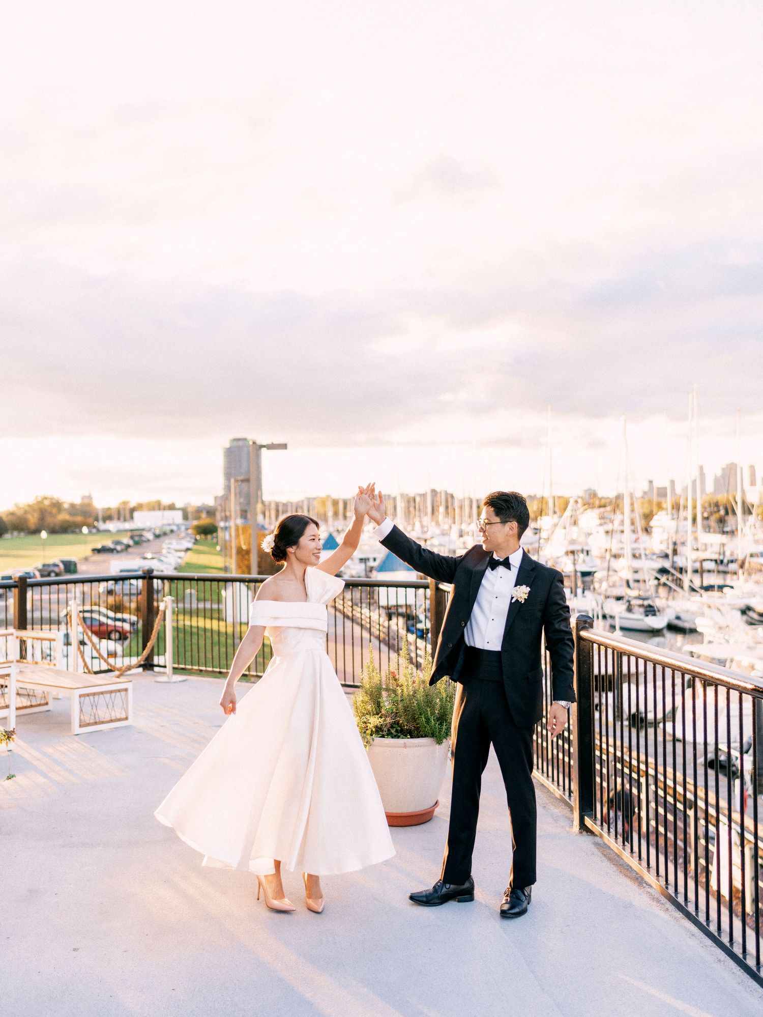 Wedding portraits captured on a deck overlooking a marina with boats in the background.