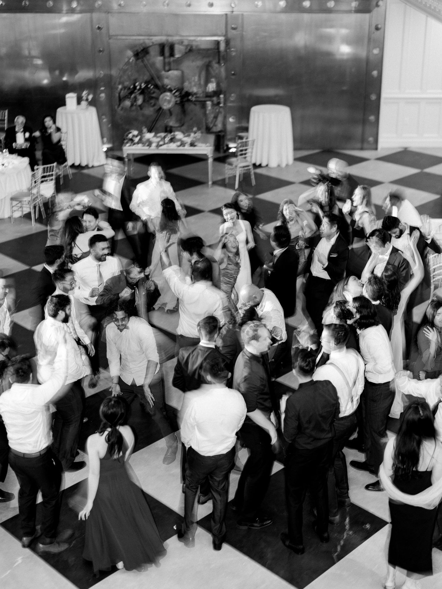 Black and white reception photo of wedding guests dancing and celebrating.