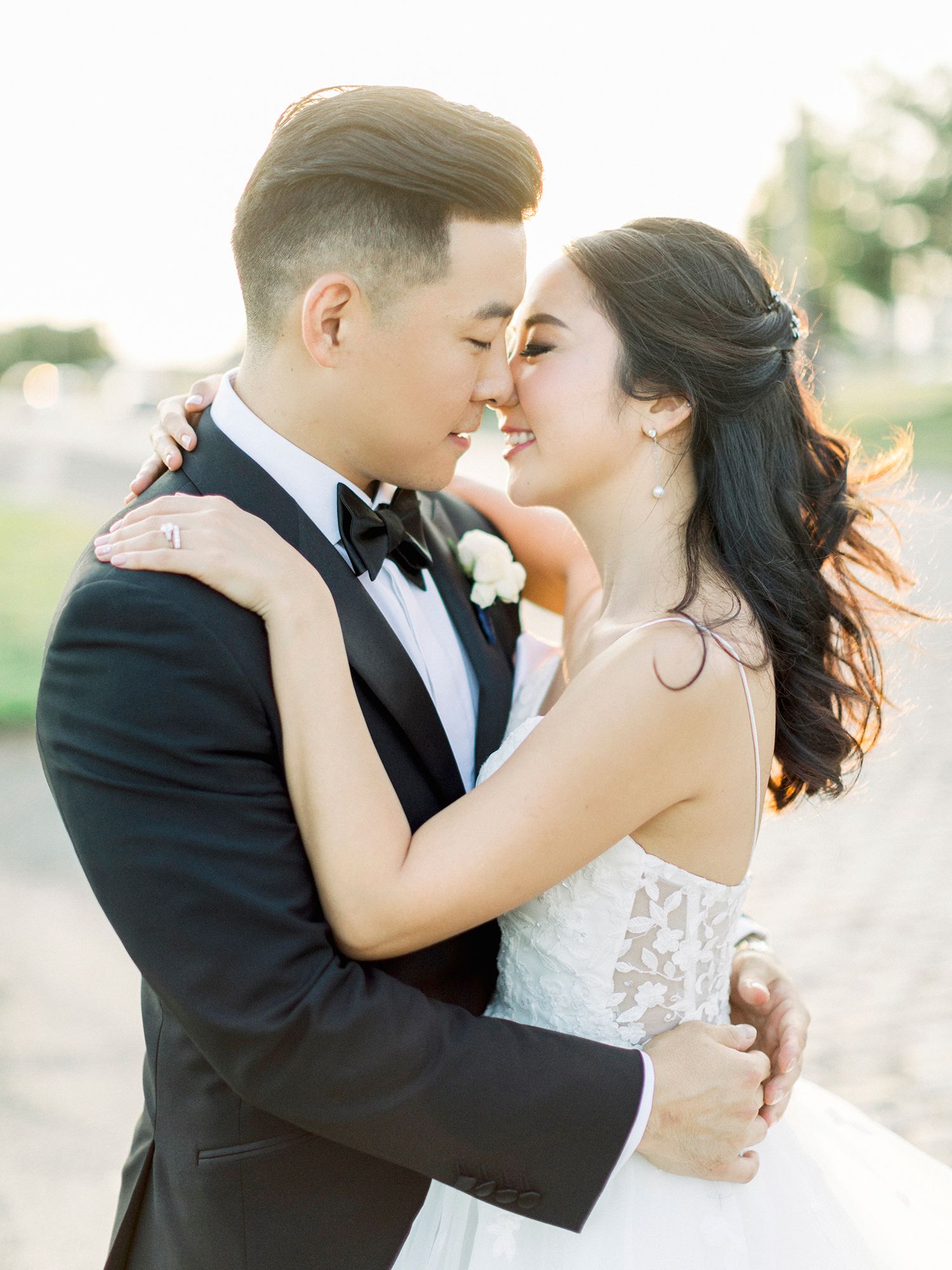 A romantic wedding portrait of a couple embracing outdoors in formal attire. NYC wedding photographer.