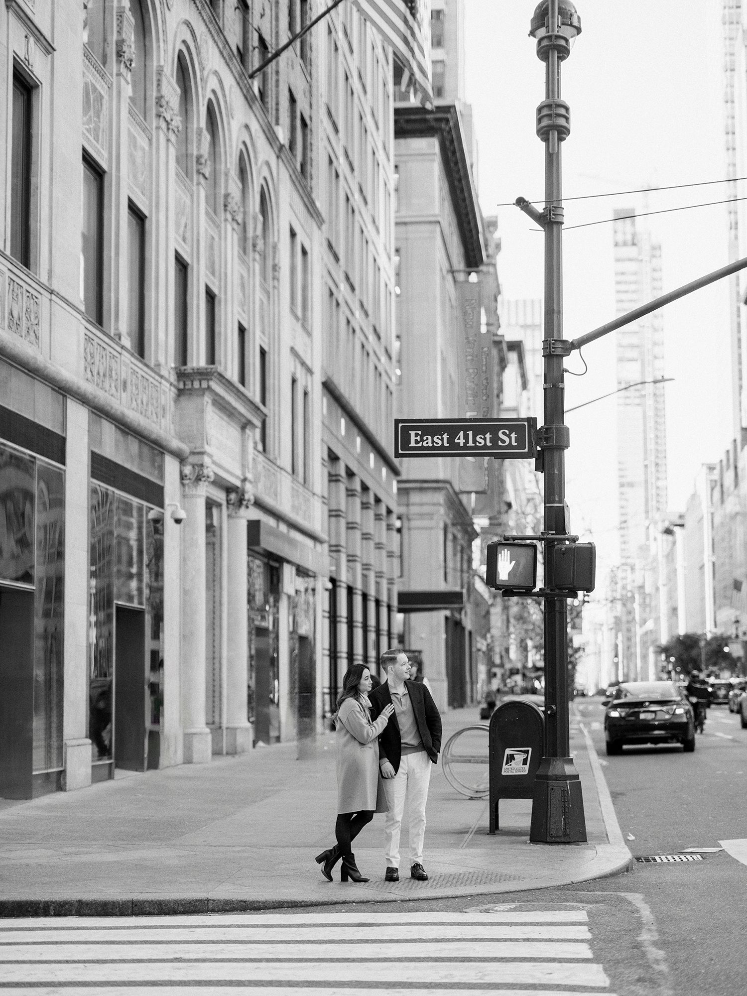 Black and white urban street scene with figures walking near East 41st Street sign.