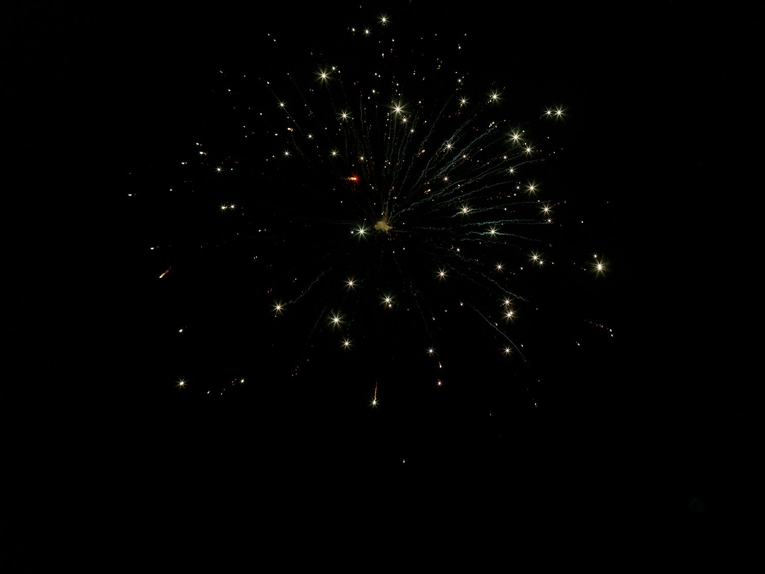 Twinkling fireworks light up the night sky in a dazzling display of celebration.