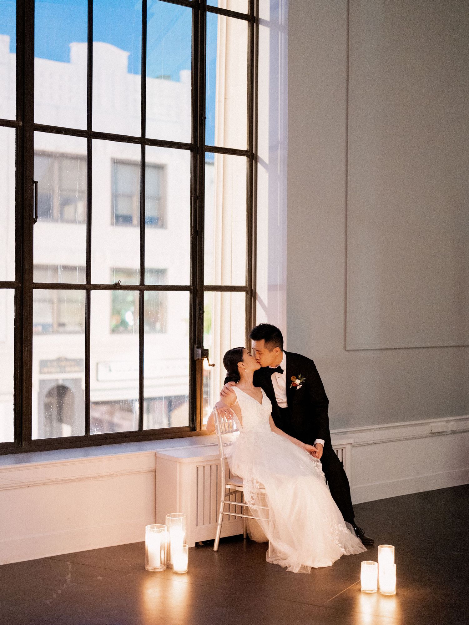 Romantic silhouettes against large windows with glowing candles creating an intimate atmosphere.
