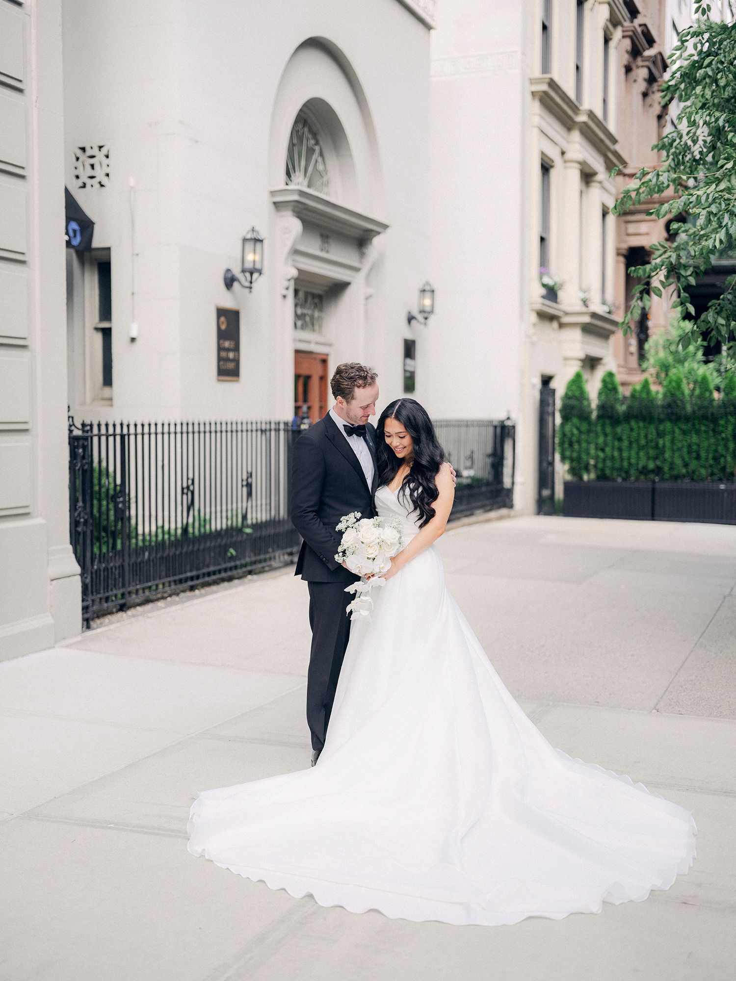 Wedding photos captured against classic white architecture with elegant columns and archways. NYC wedding photographer.