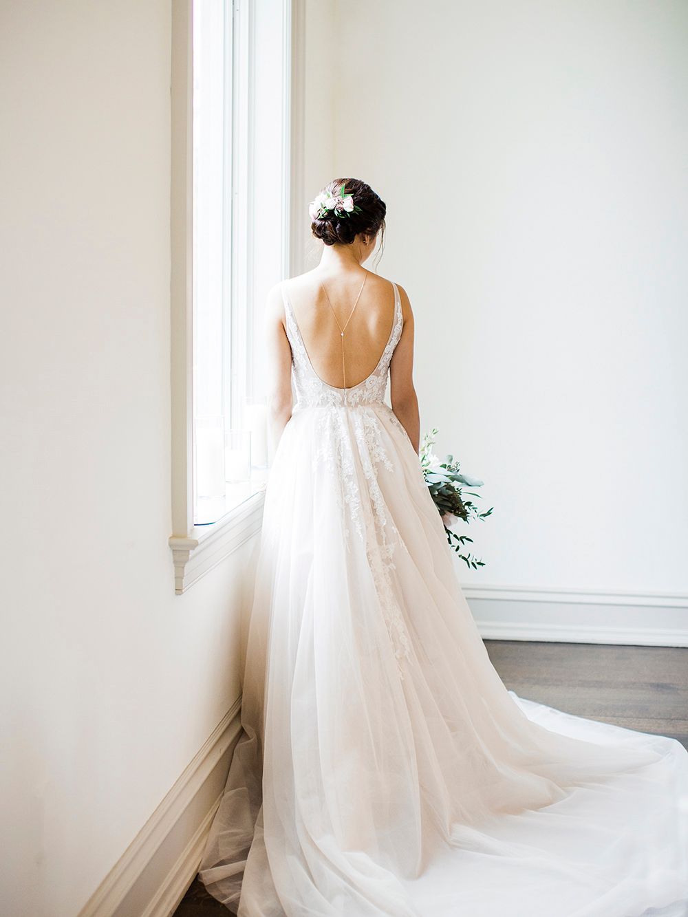 Flowing white wedding gown with delicate lace details and long train.