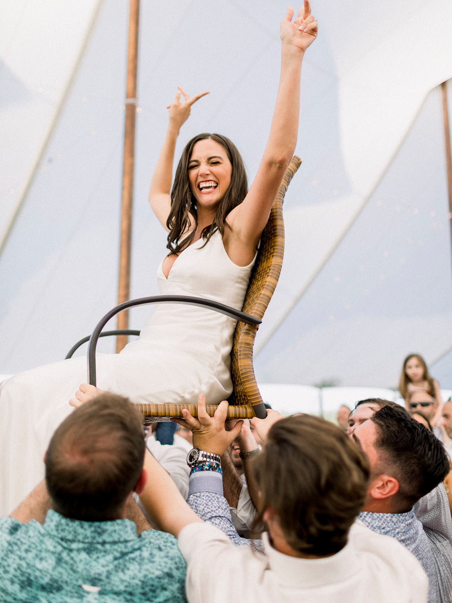 Wedding guests lift and celebrate during an energetic dance party moment.