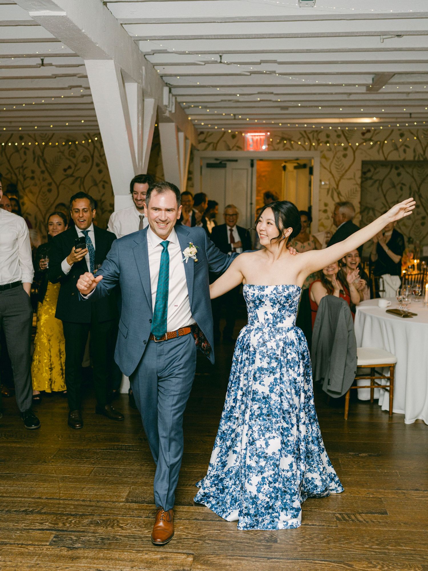 A celebration in a reception hall with string lights and dancing.