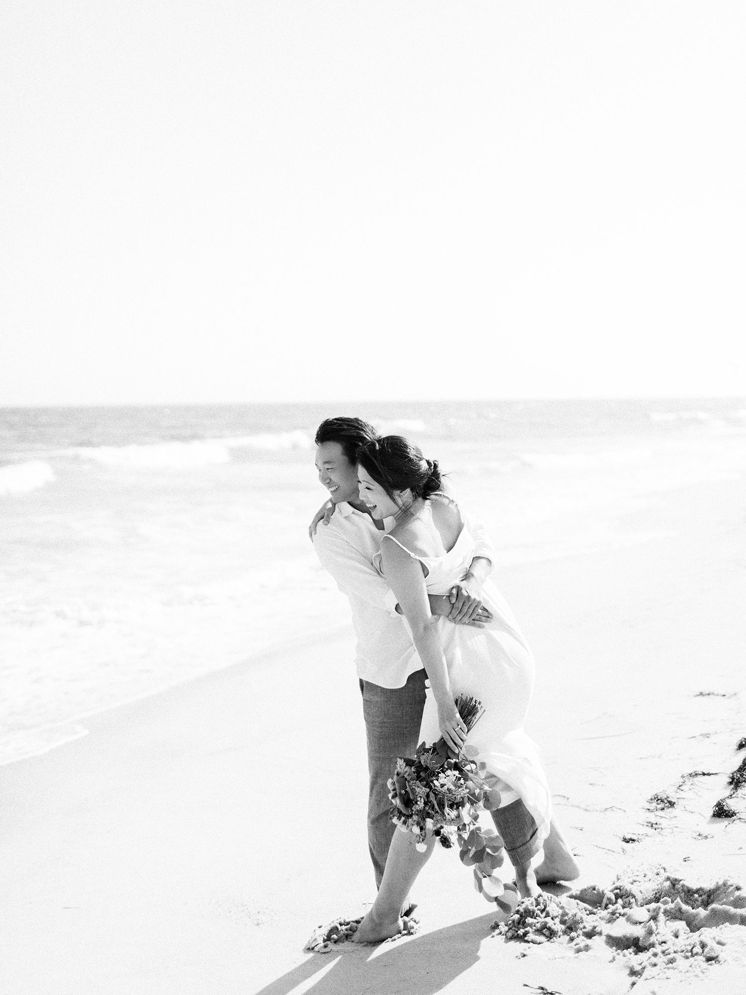 A playful black and white beach scene with waves in the background.