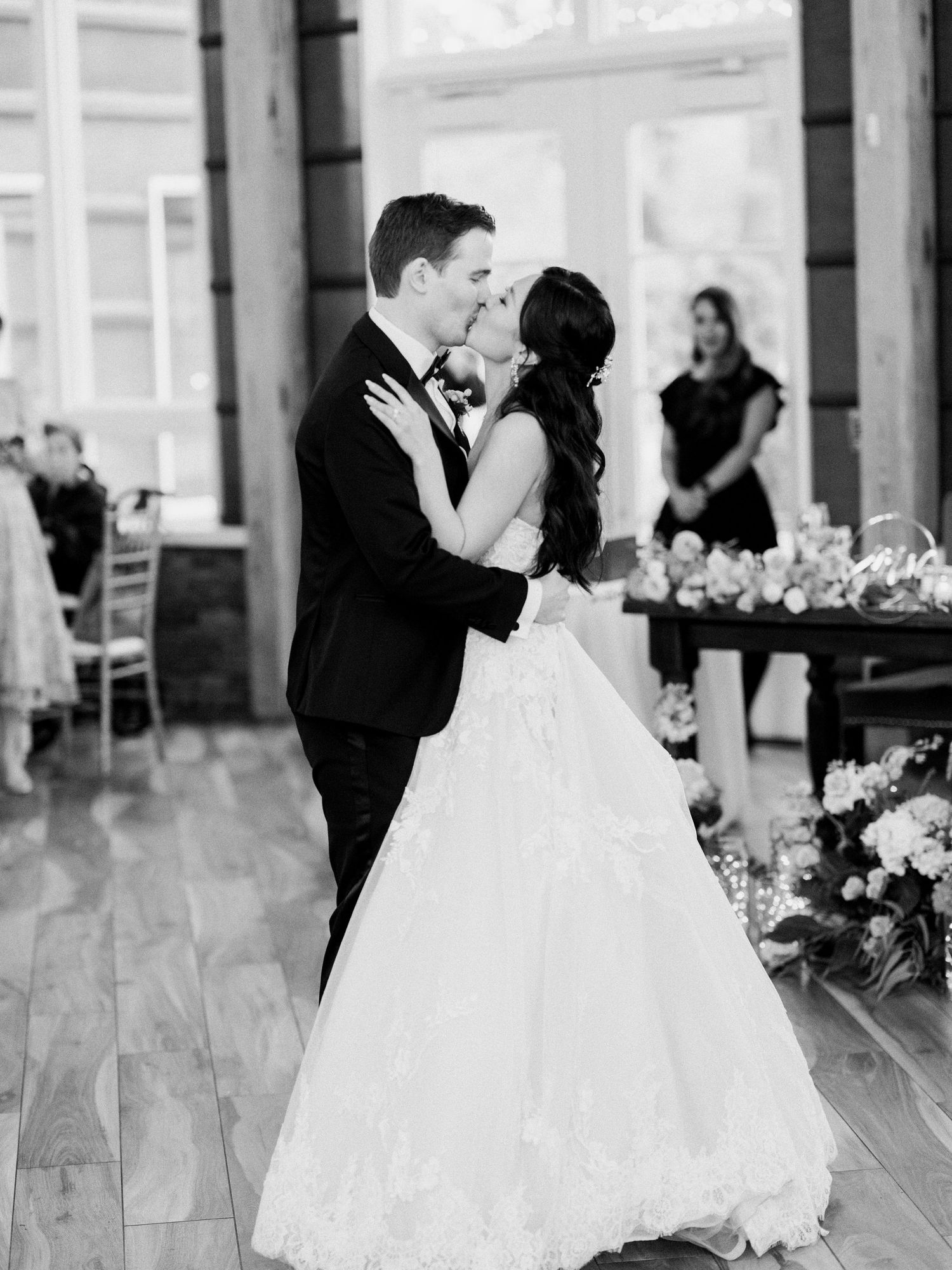 Indoor wedding reception dance sequence with elegant floral arrangements.