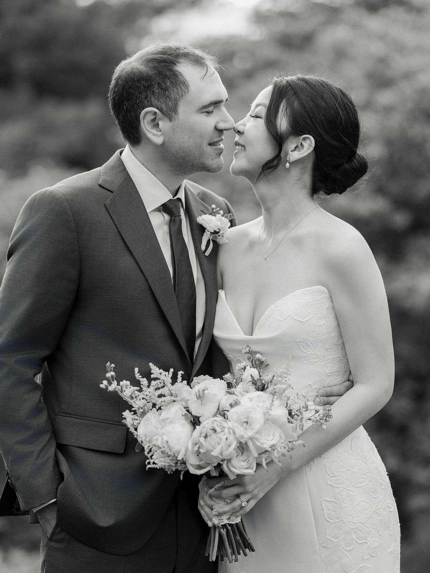 Black and white wedding portraits showing tender moments between newlyweds with bridal bouquet.