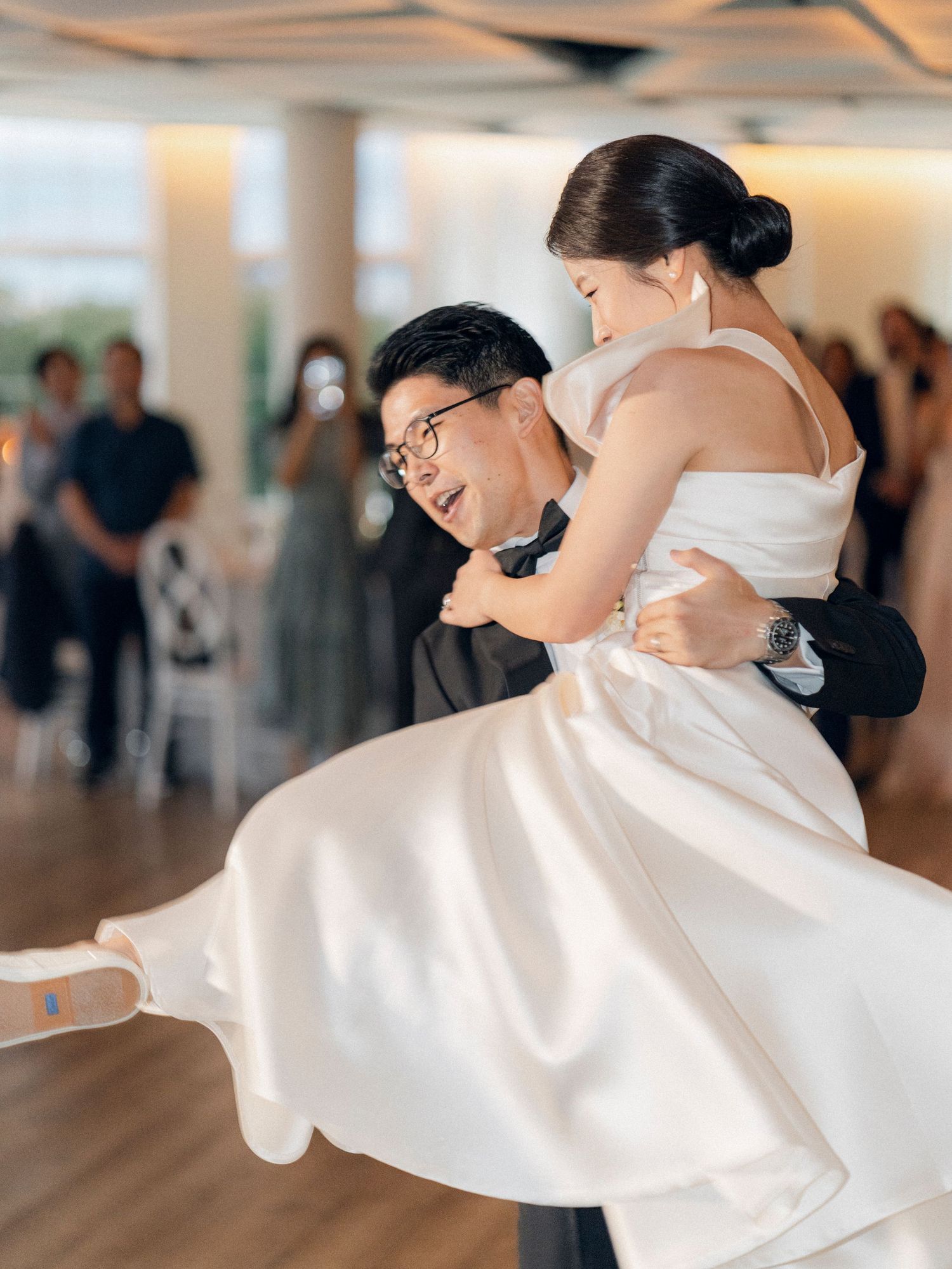 Joyful couple performs a romantic dance lift during their wedding celebration.