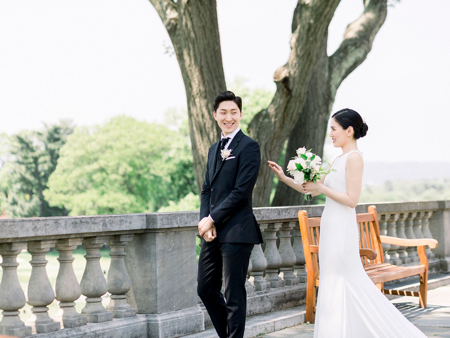 Elegant wedding photo session under mature trees on a stone terrace.