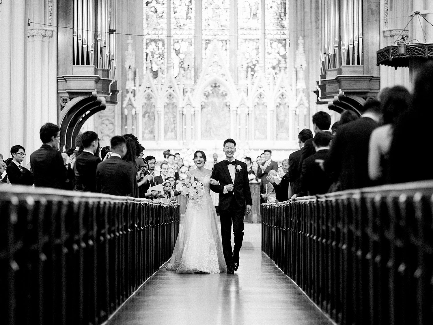 A wedding ceremony in a grand cathedral with ornate organ pipes and stained glass windows.