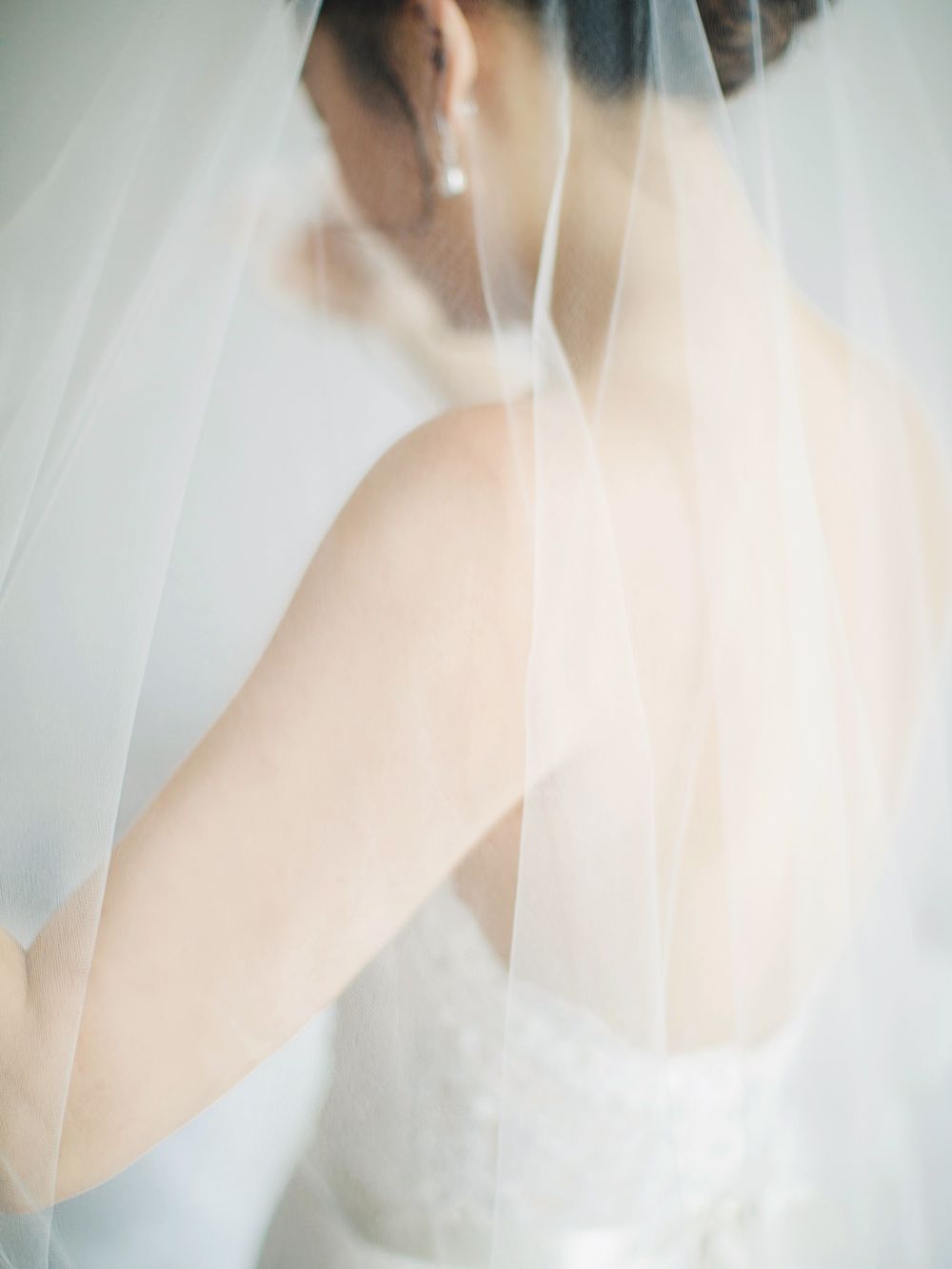 Ethereal bridal portrait showing delicate veil details and bare shoulders.