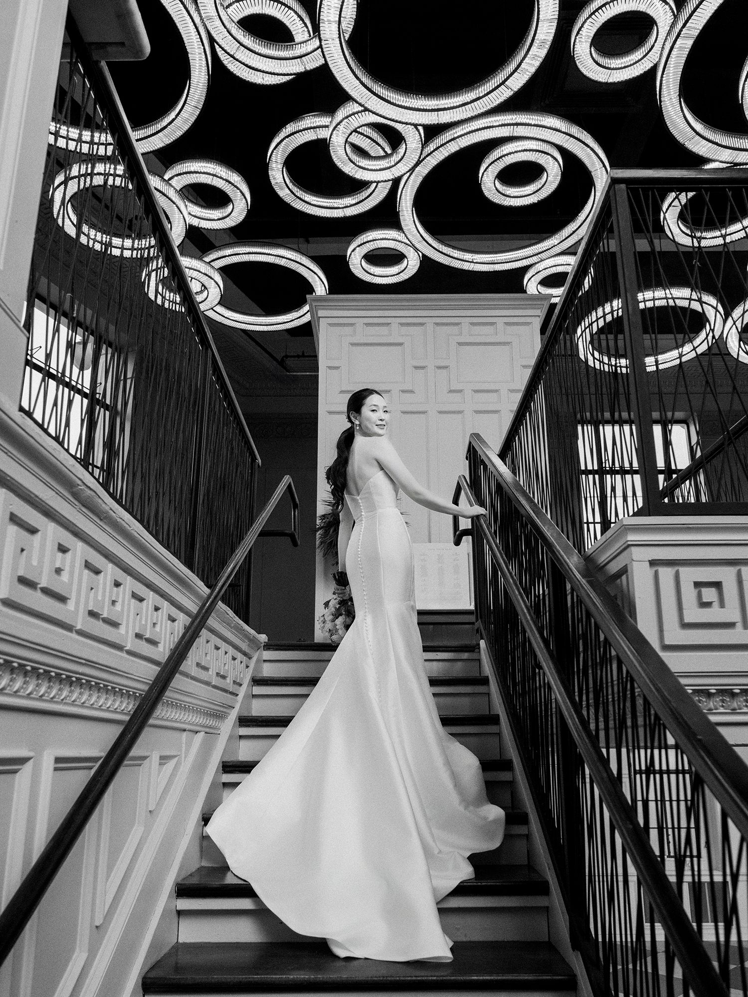 Wedding gowns displayed on mannequins against ornate black iron staircase railings. NJ Wedding photographer.