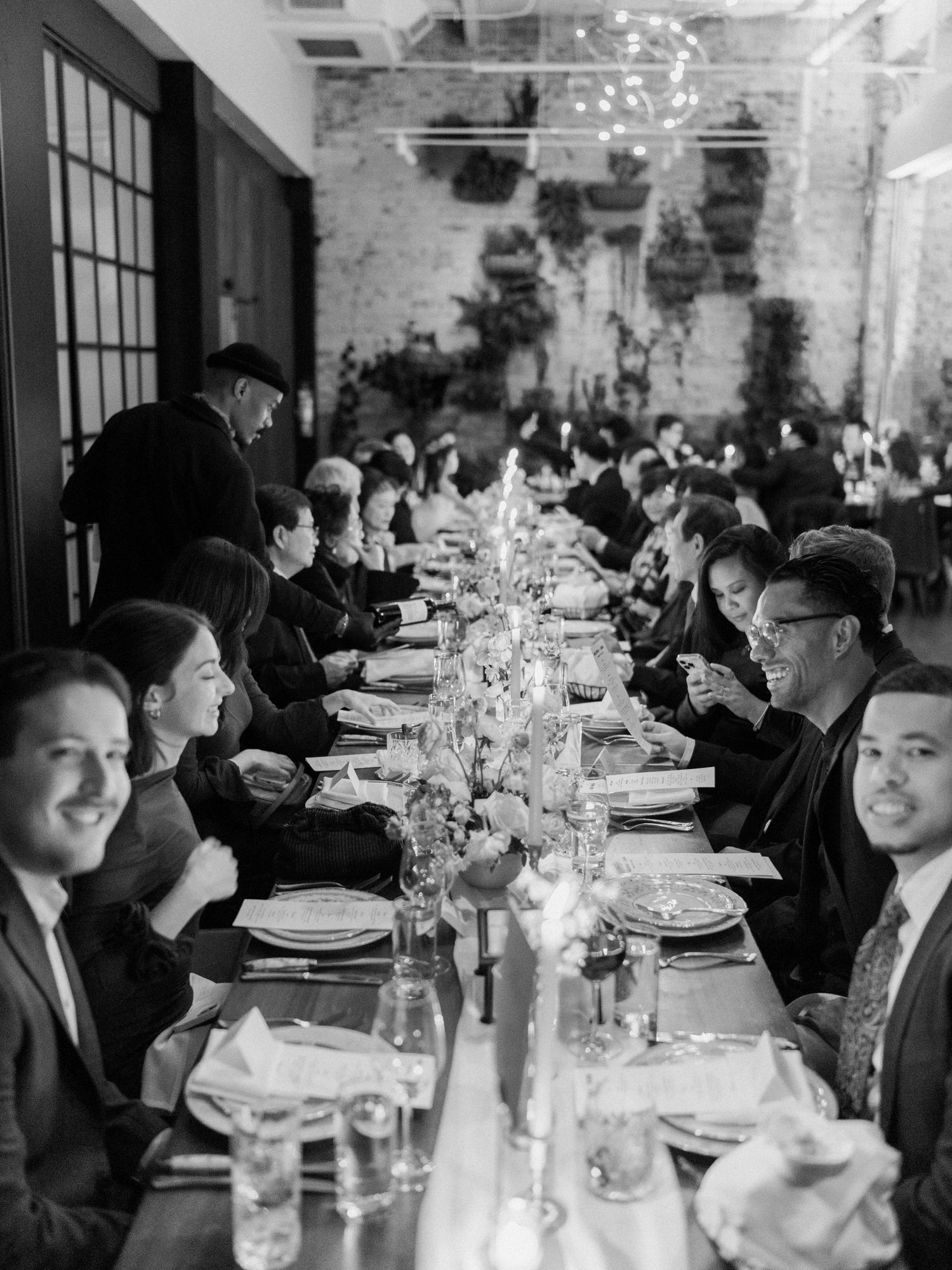 Elegant wedding reception table setting with glassware and centerpieces in an industrial venue.