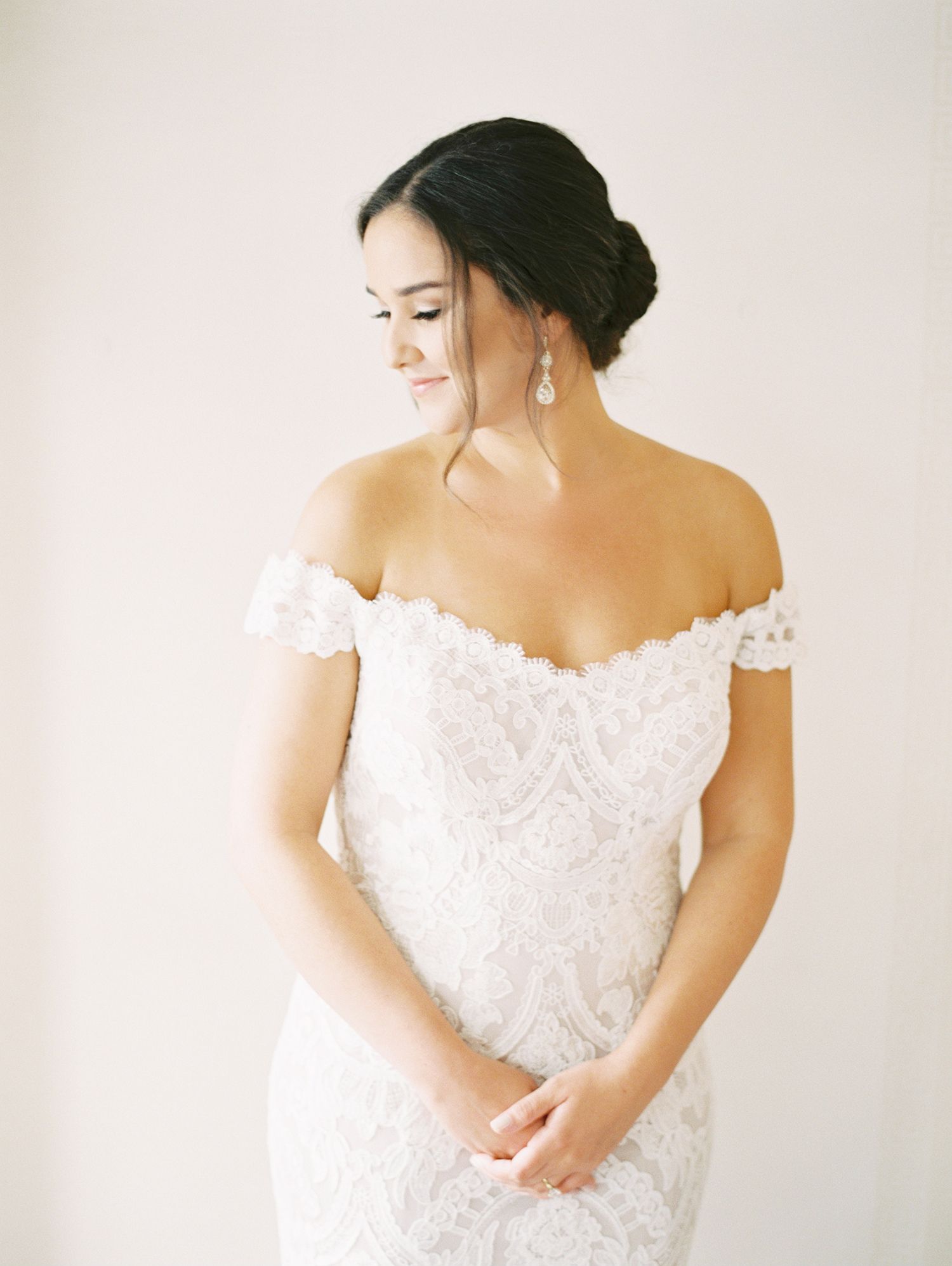 Elegant off-shoulder lace wedding dress with delicate details.