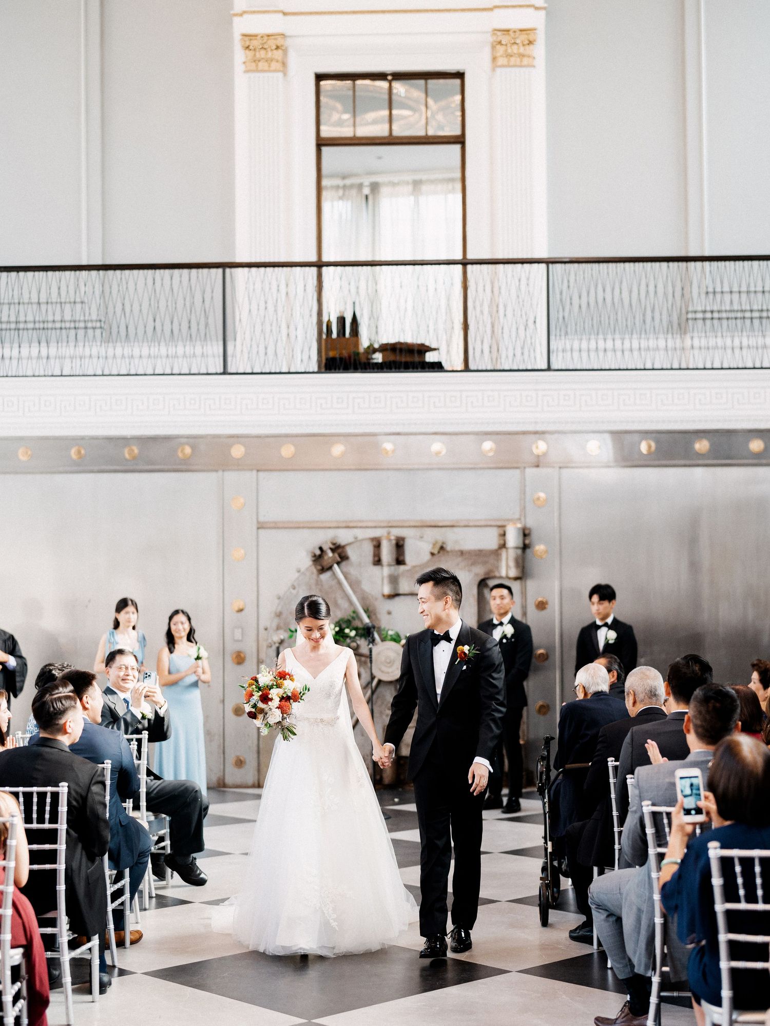 Modern white wedding ceremony space with string lights and minimalist industrial decor.