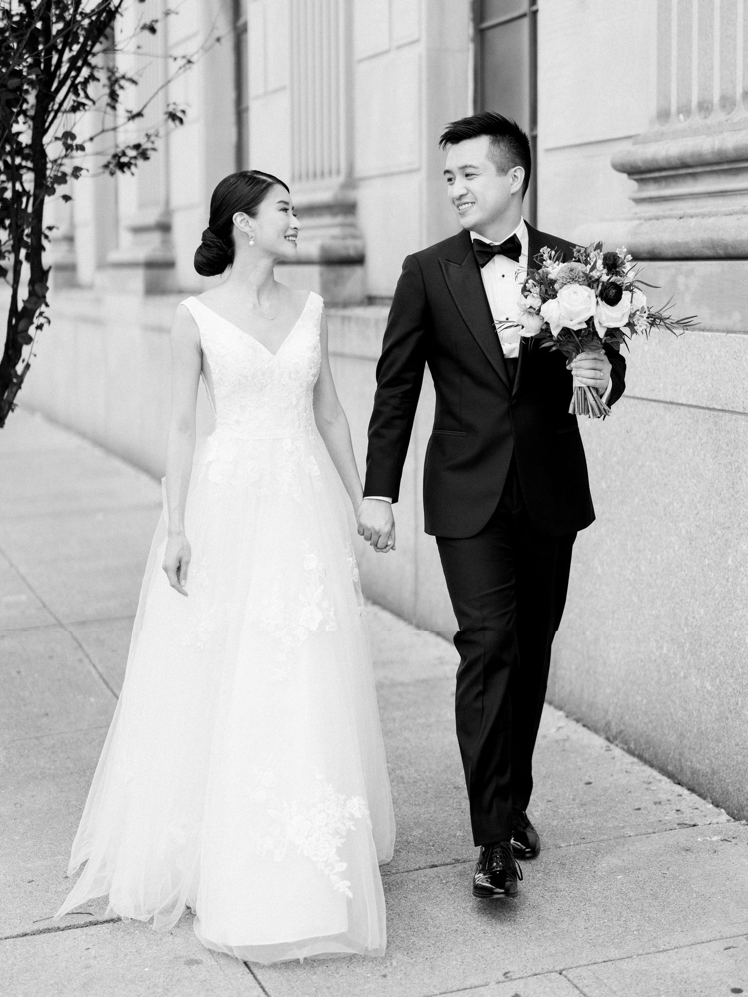 Wedding photo series showing couple walking together outside a classical building.