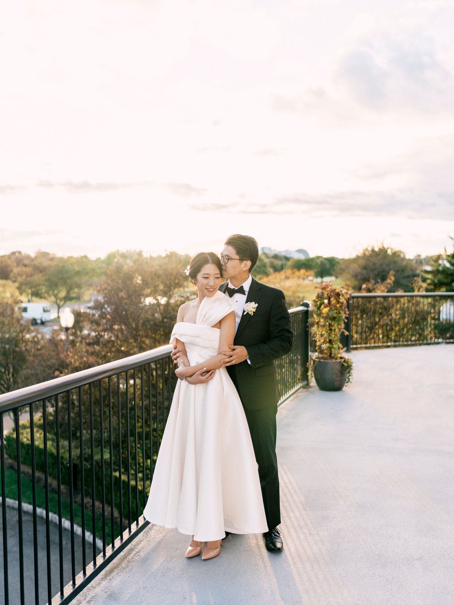 A romantic outdoor wedding photoshoot at sunset with a scenic natural backdrop.