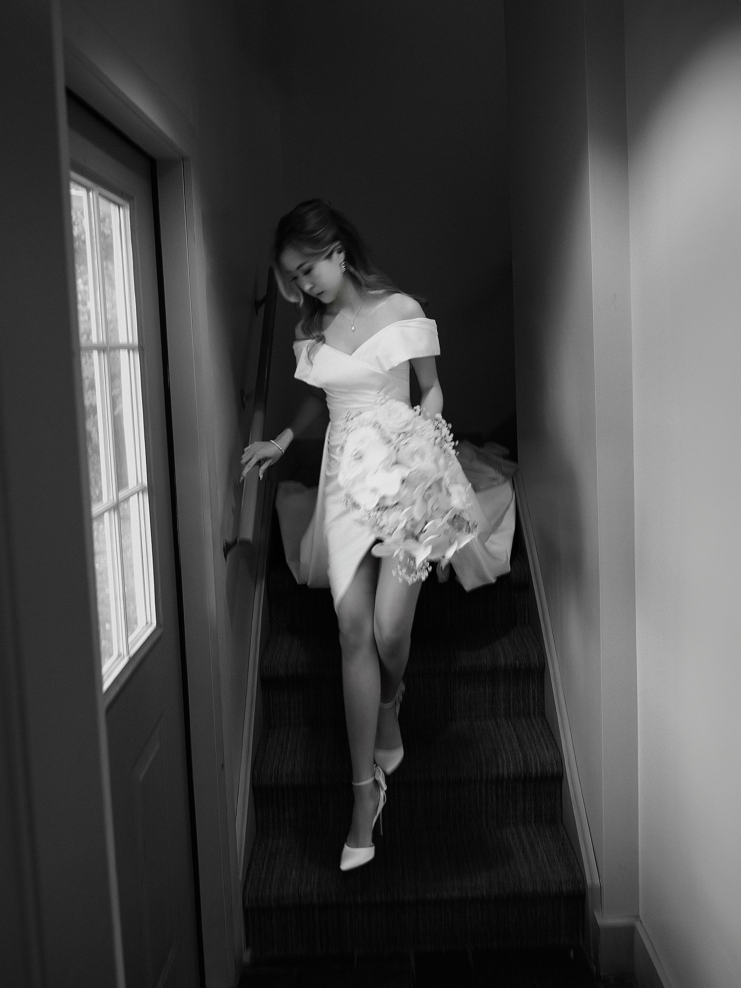 Artistic black and white photos of wedding dress details in window light.