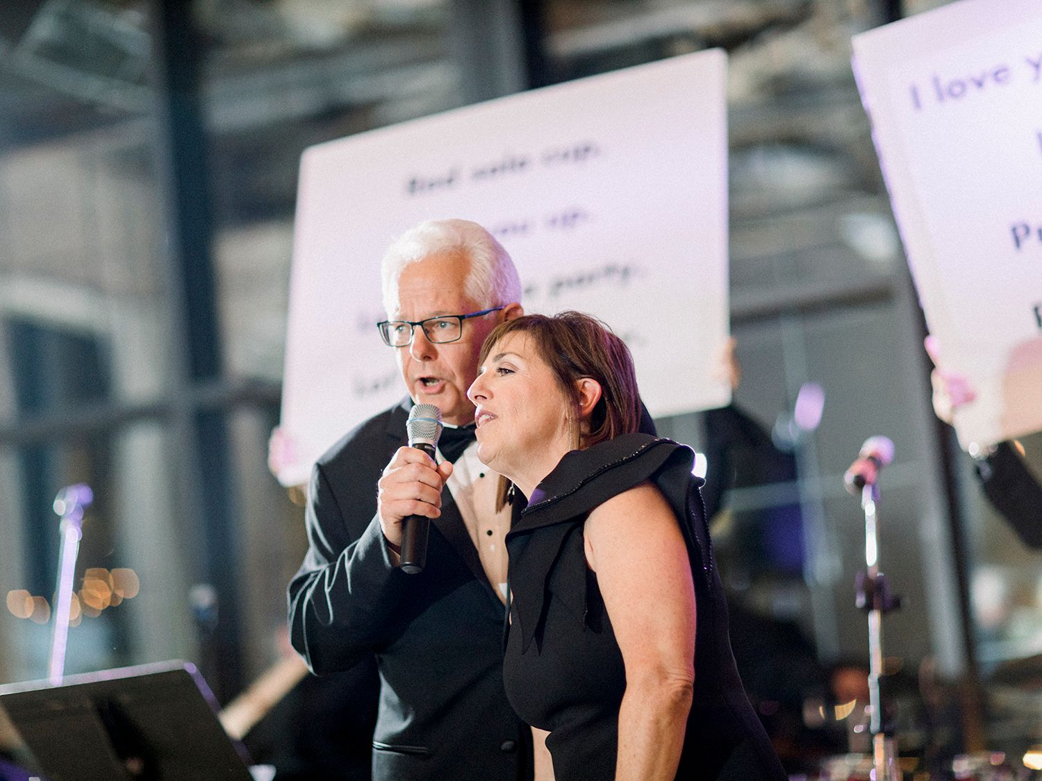 Musicians performing at an elegant event with white backdrops and professional lighting.