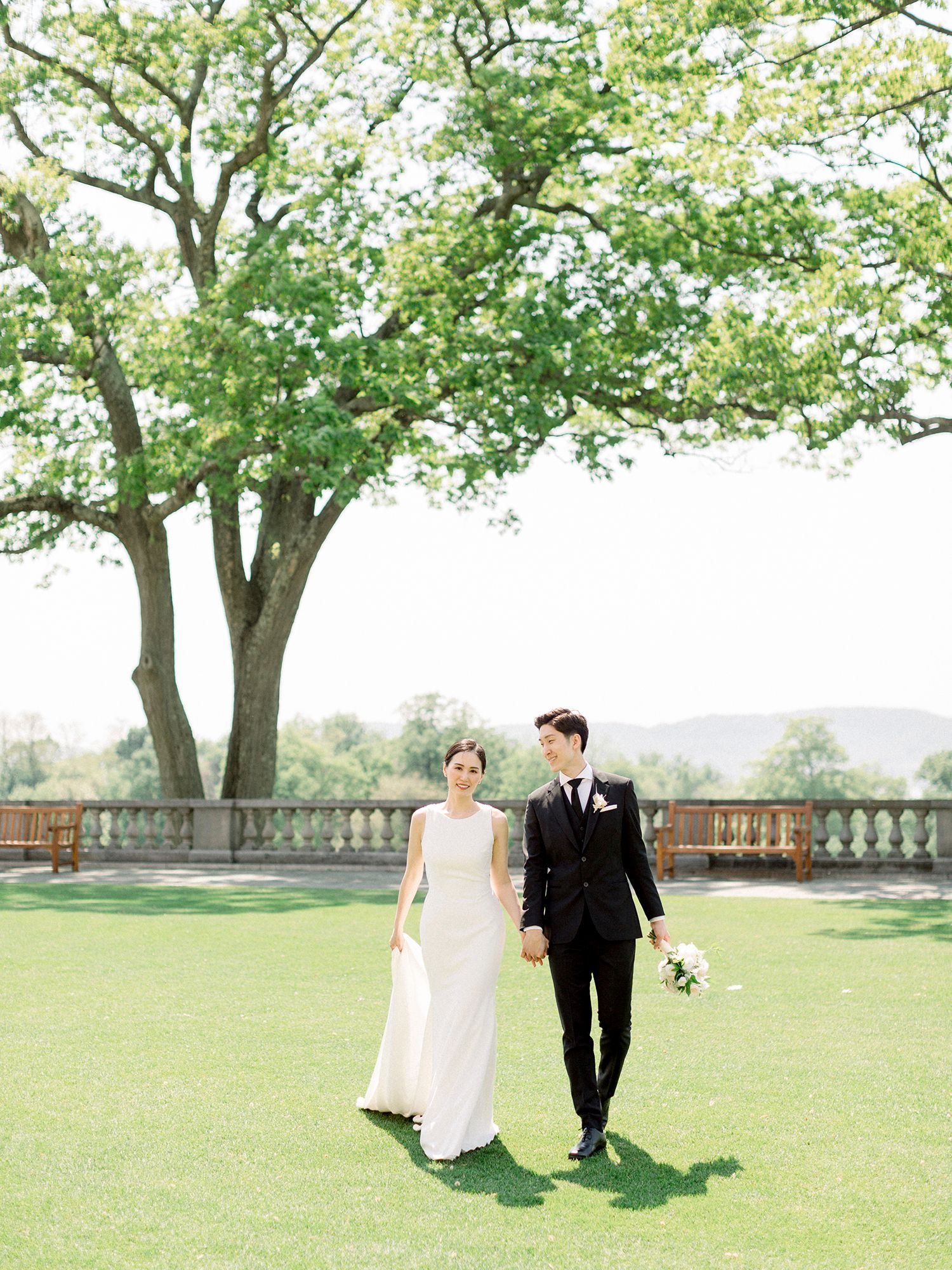 Spring wedding portraits under blooming trees with stone balustrade in background.