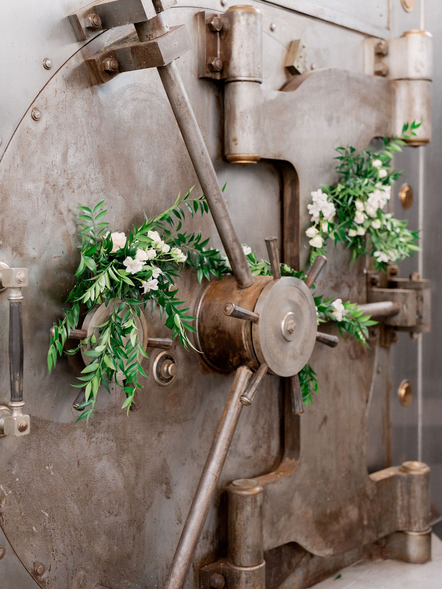 Industrial wall decorated with greenery garlands and vintage metal fixtures.
