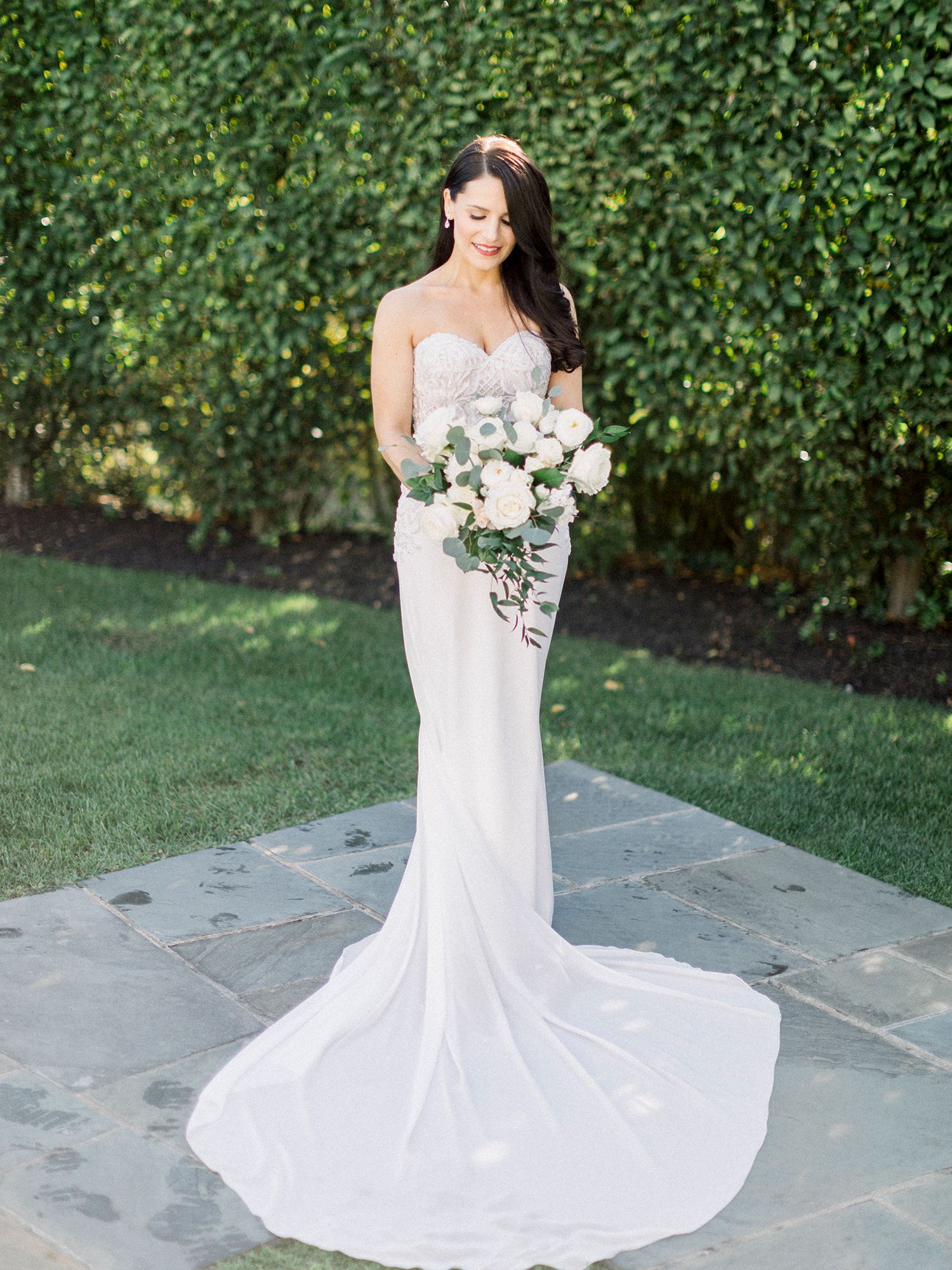 Elegant bridal portraits showing flowing white wedding dress against garden backdrop.