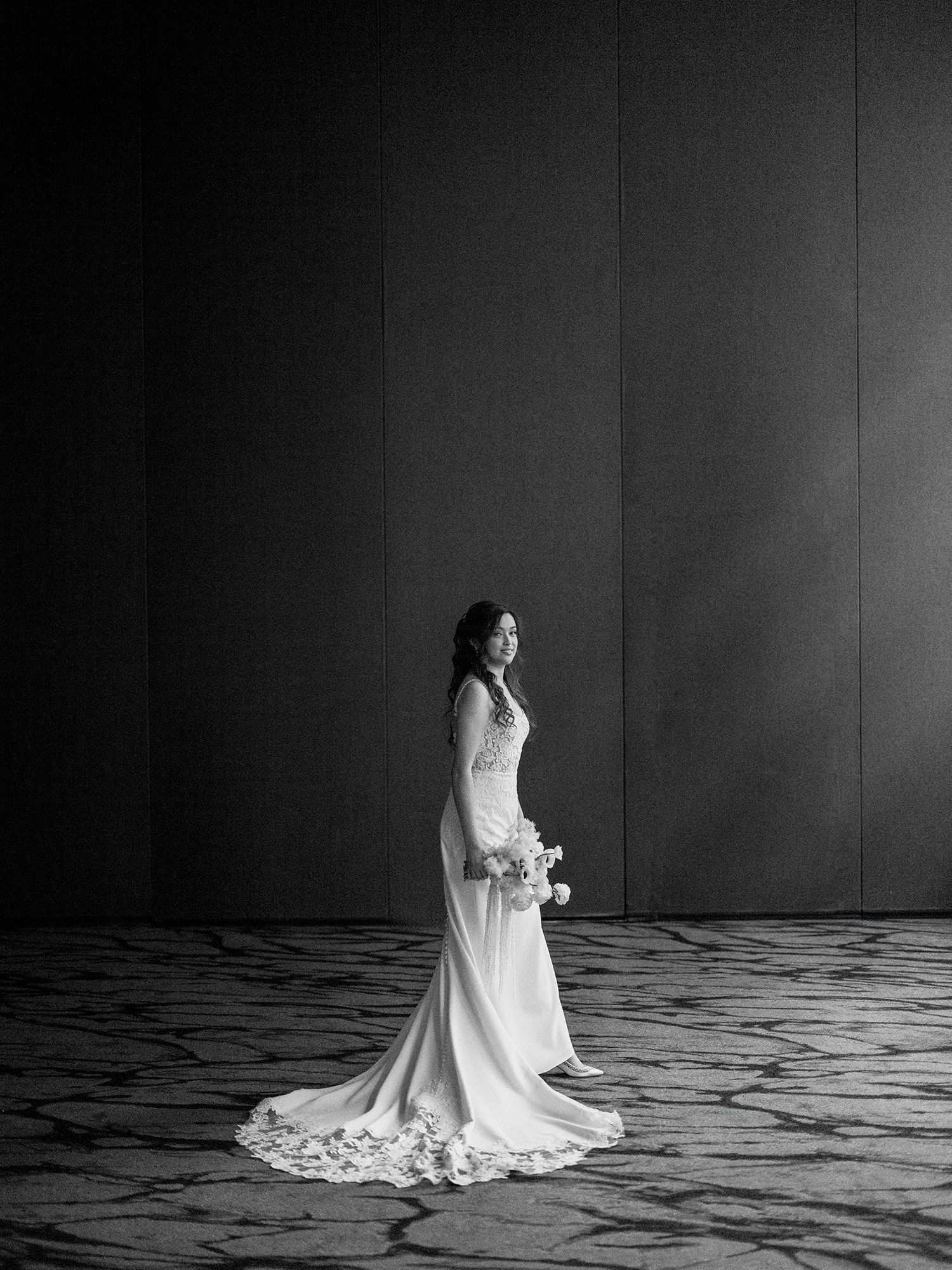 Dramatic black and white bridal portrait with flowing wedding dress against dark background. W hotel in Hoboken. NYC wedding photographer.