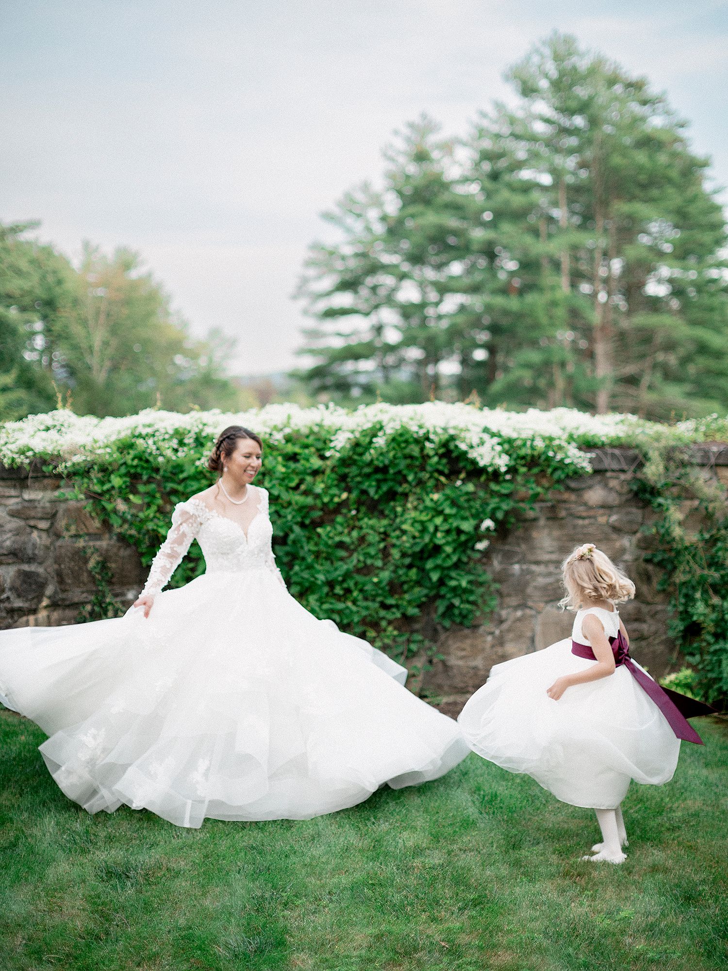 Flowing white wedding dress twirling in a series of artistic shots on green grass. NYC wedding photographer.
