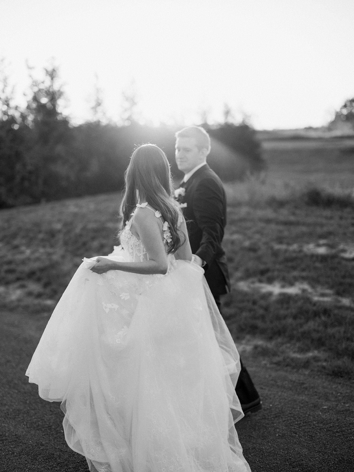 Black and white wedding portrait captured on a hillside during sunset. NYC wedding photographer.