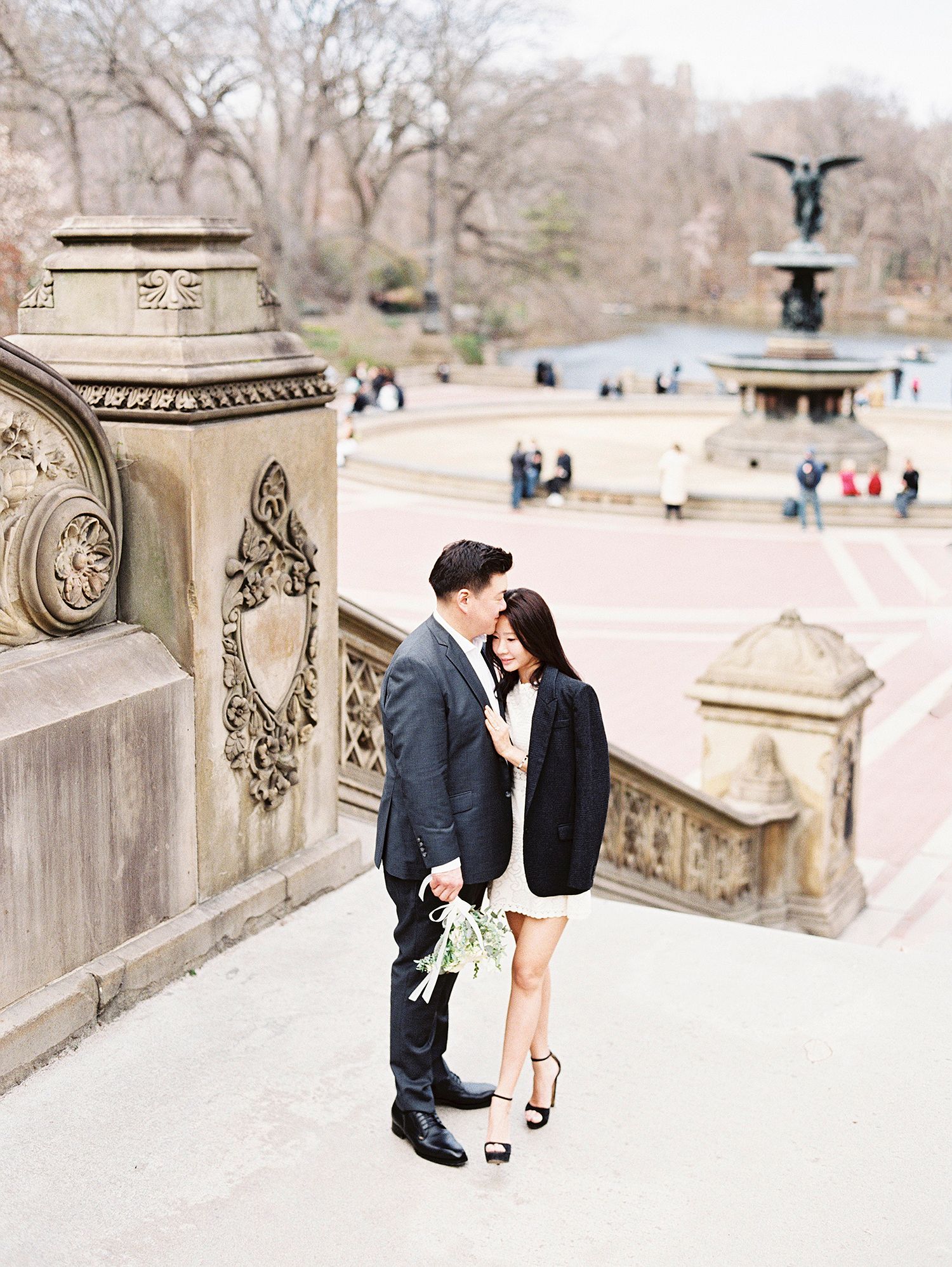 A couple poses romantically on Bethesda Terrace in Central Park during winter.