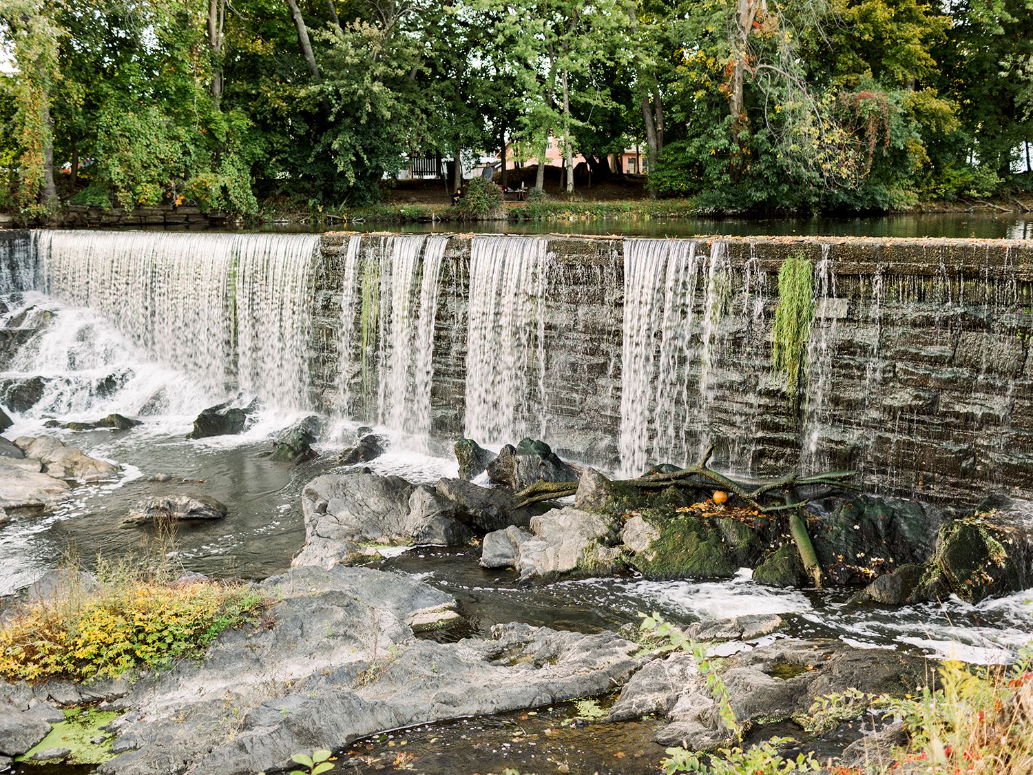 Scenic waterfall cascading over stone ledges in a natural landscape setting.