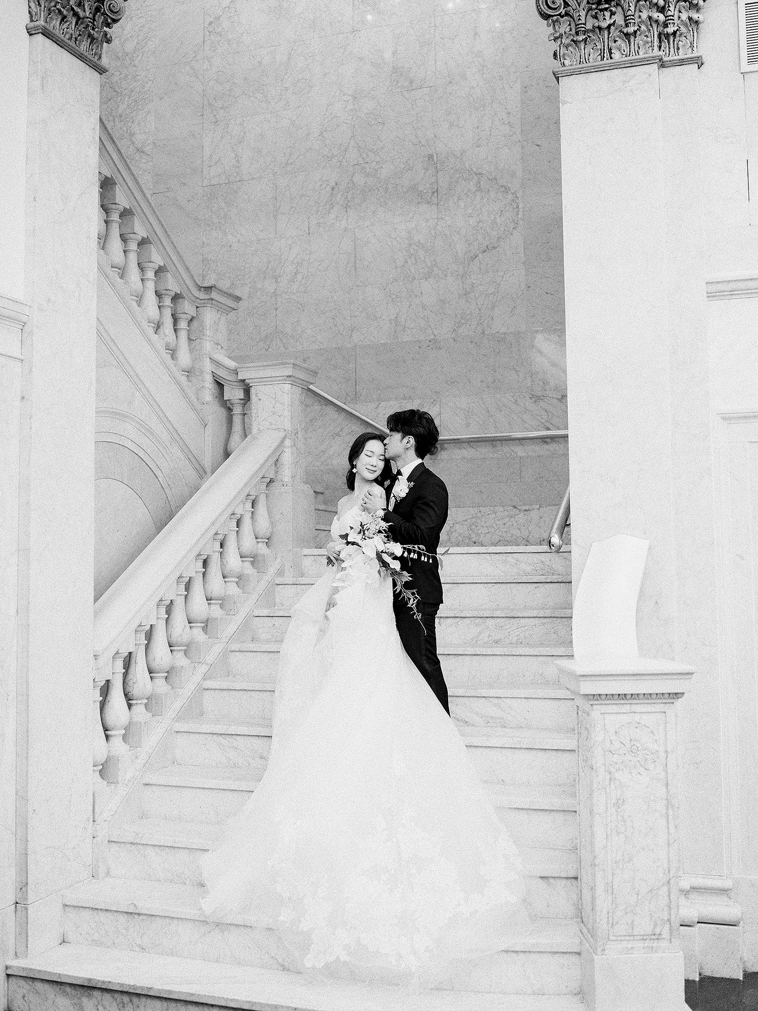 Classic black and white wedding portraits on a grand staircase. NYC wedding photographer.