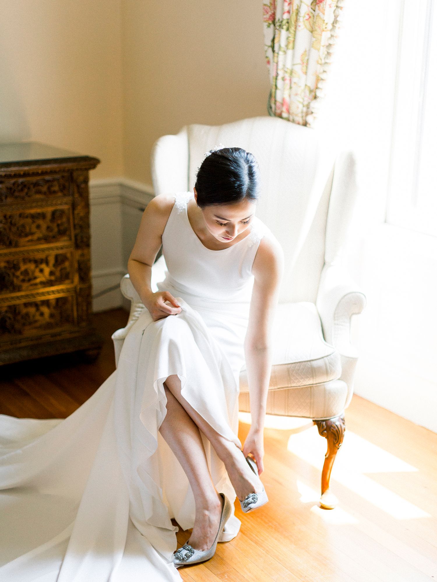 Getting ready scene showing wedding dress details and preparations in natural window light.