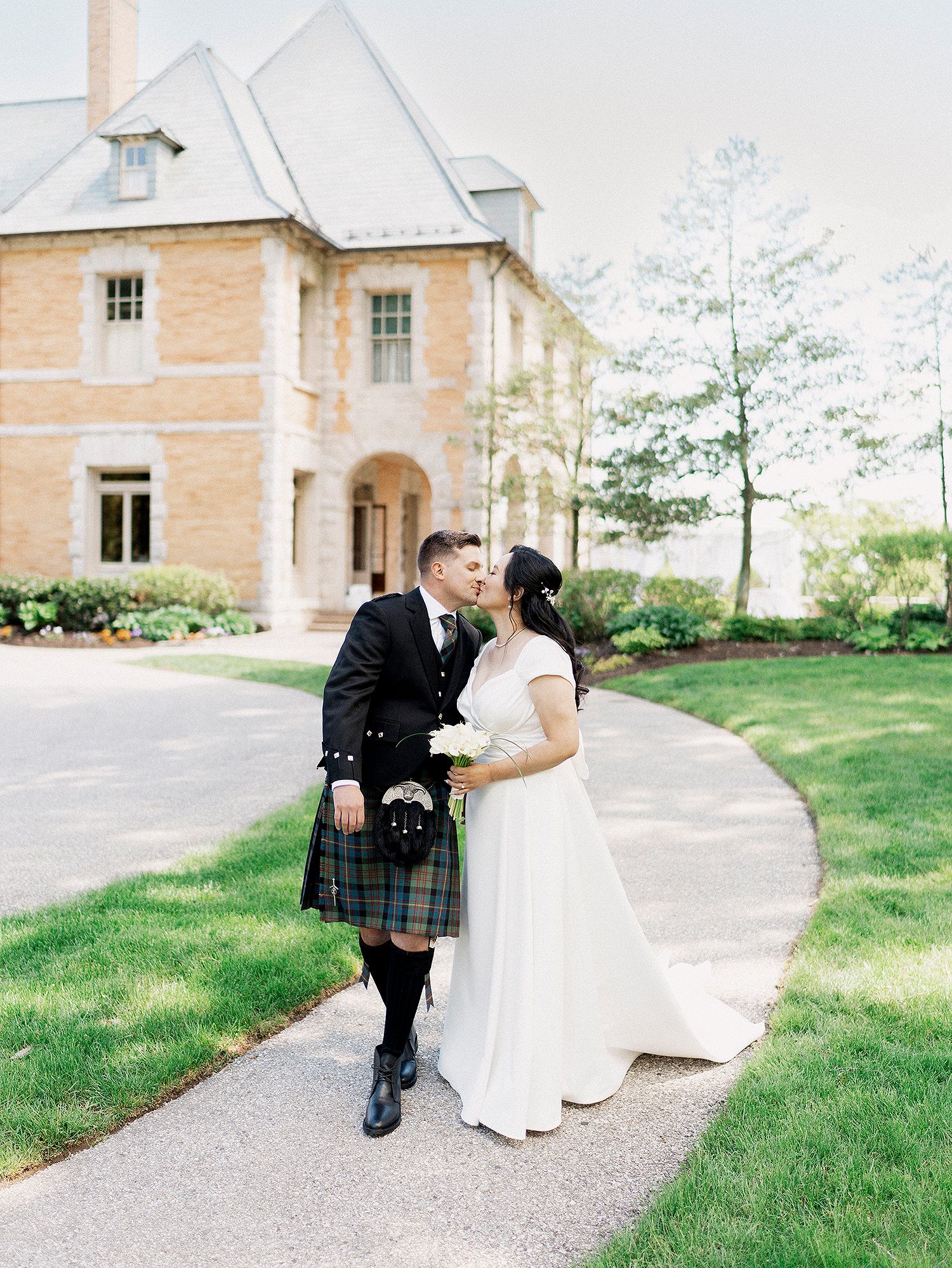 Wedding couple in traditional dress sharing romantic moments on a garden pathway. PA wedding photographer.