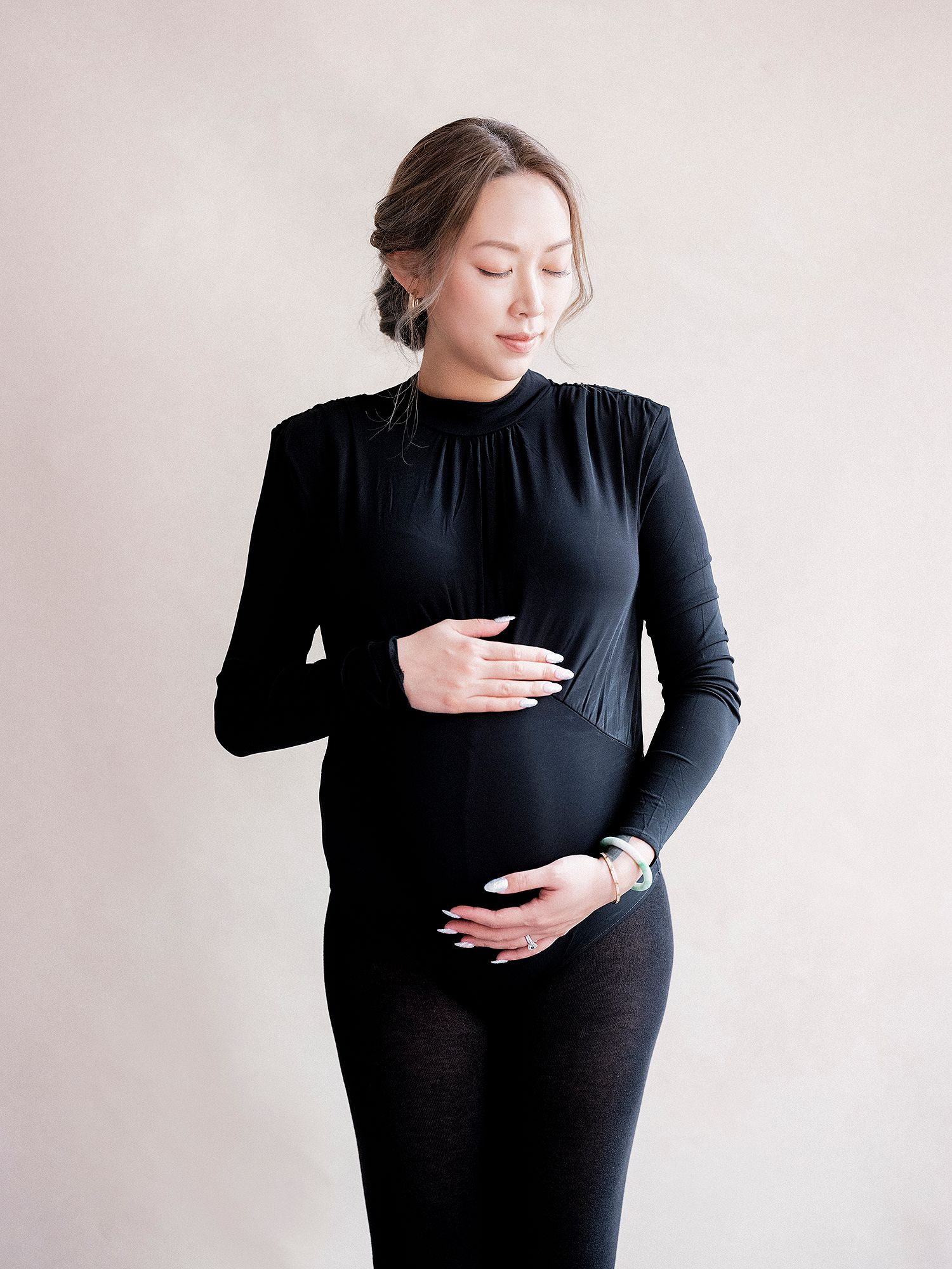 A series of artistic maternity photos showing a woman in black dress against white background highlighting her pregnant form.