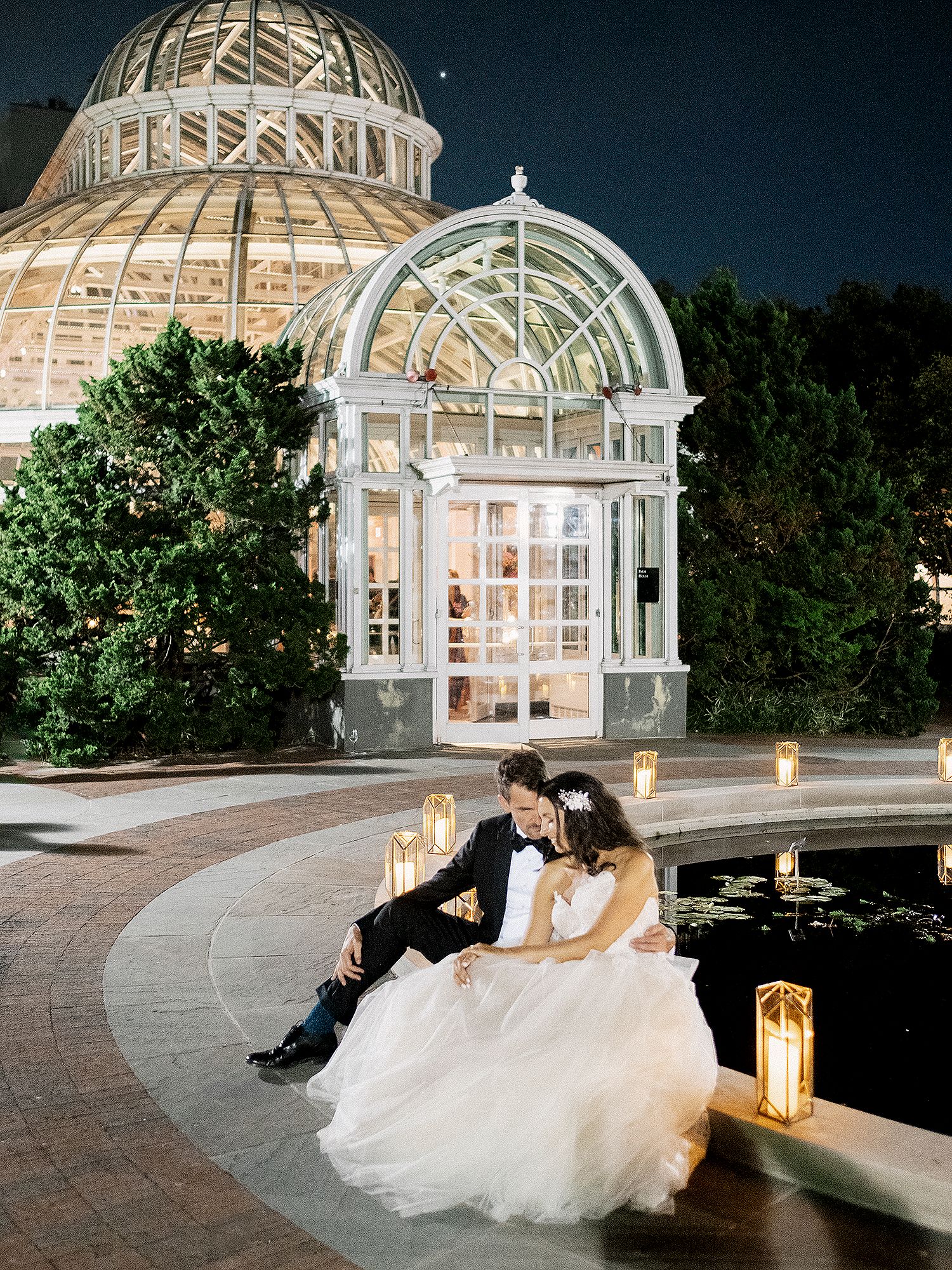 Romantic evening photos at an illuminated glass conservatory with elegant architecture. NYC wedding photographer.